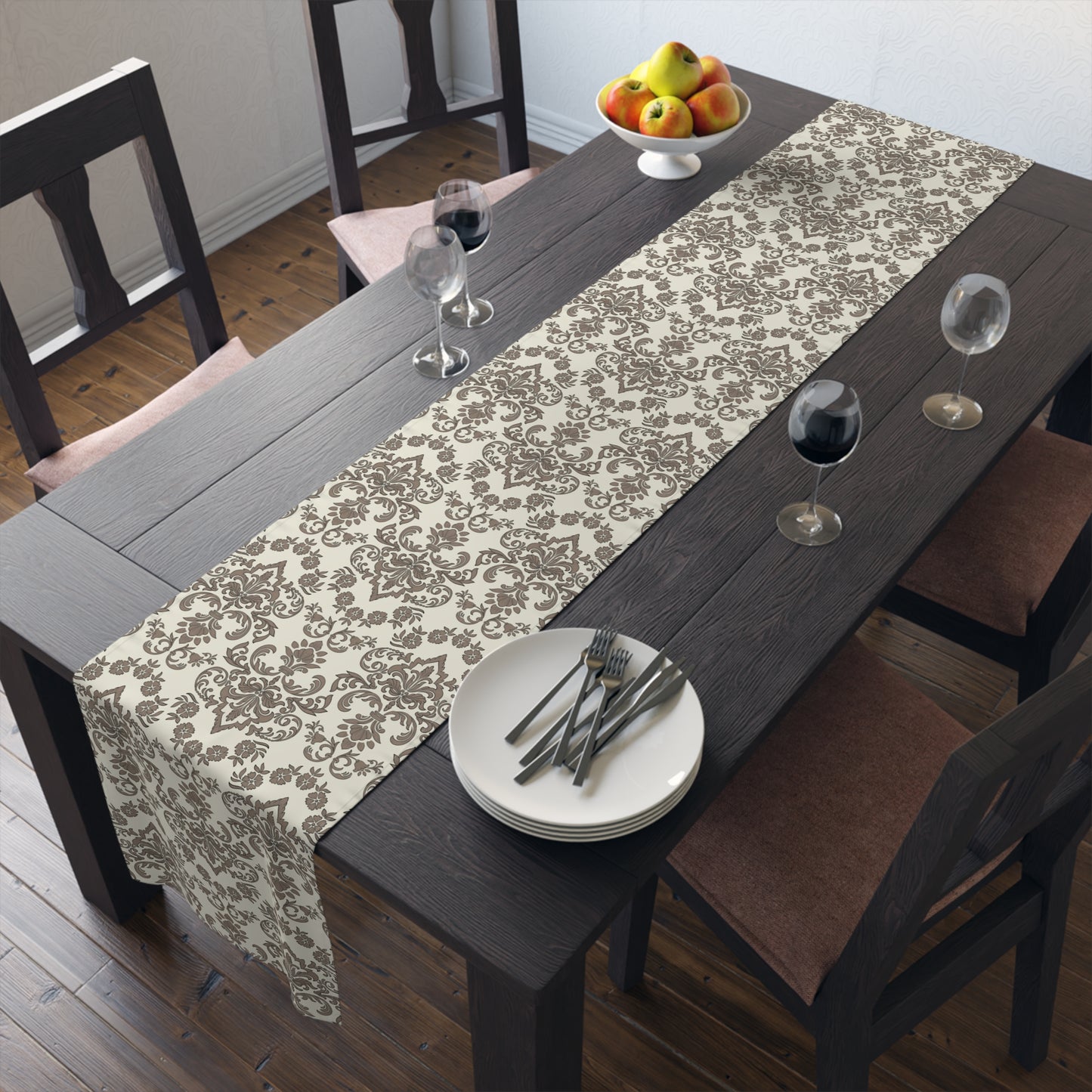 Dining table with a Baroque Mocha table runner with brown and beige damask pattern, plates, and glasses in a room.