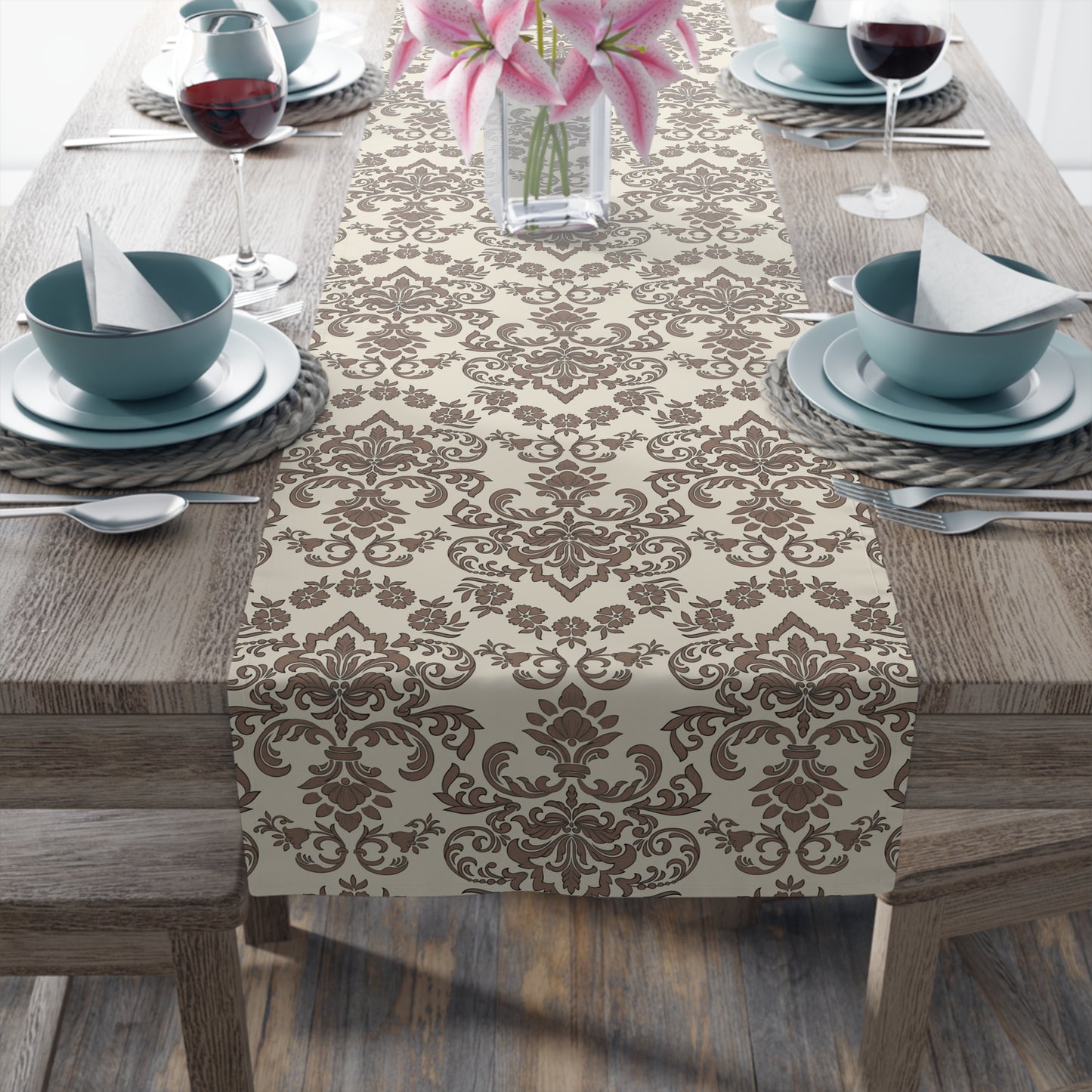 Table setting with a Baroque Mocha table runner with a brown and beige damask pattern on a wooden table.