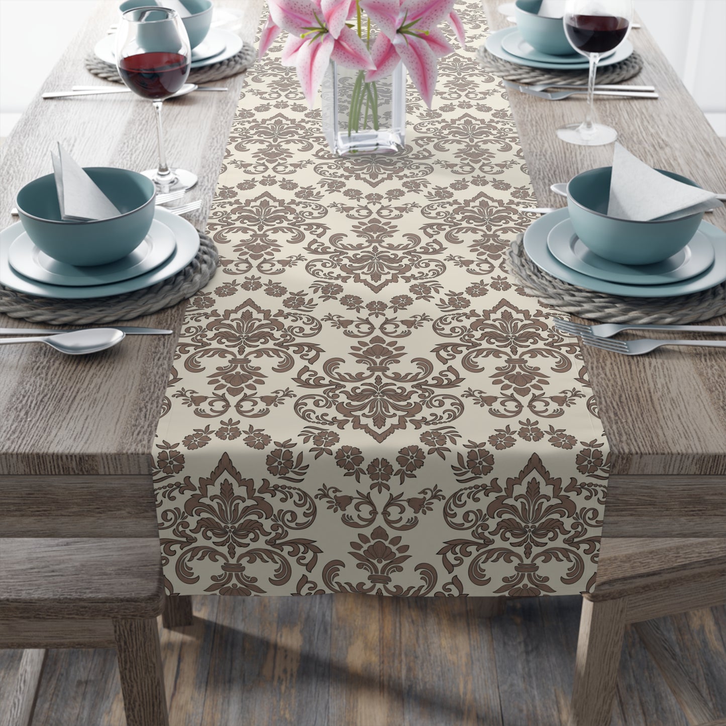 Decorative Baroque Mocha table runner with a brown and beige damask pattern on a wooden table set for dinner.