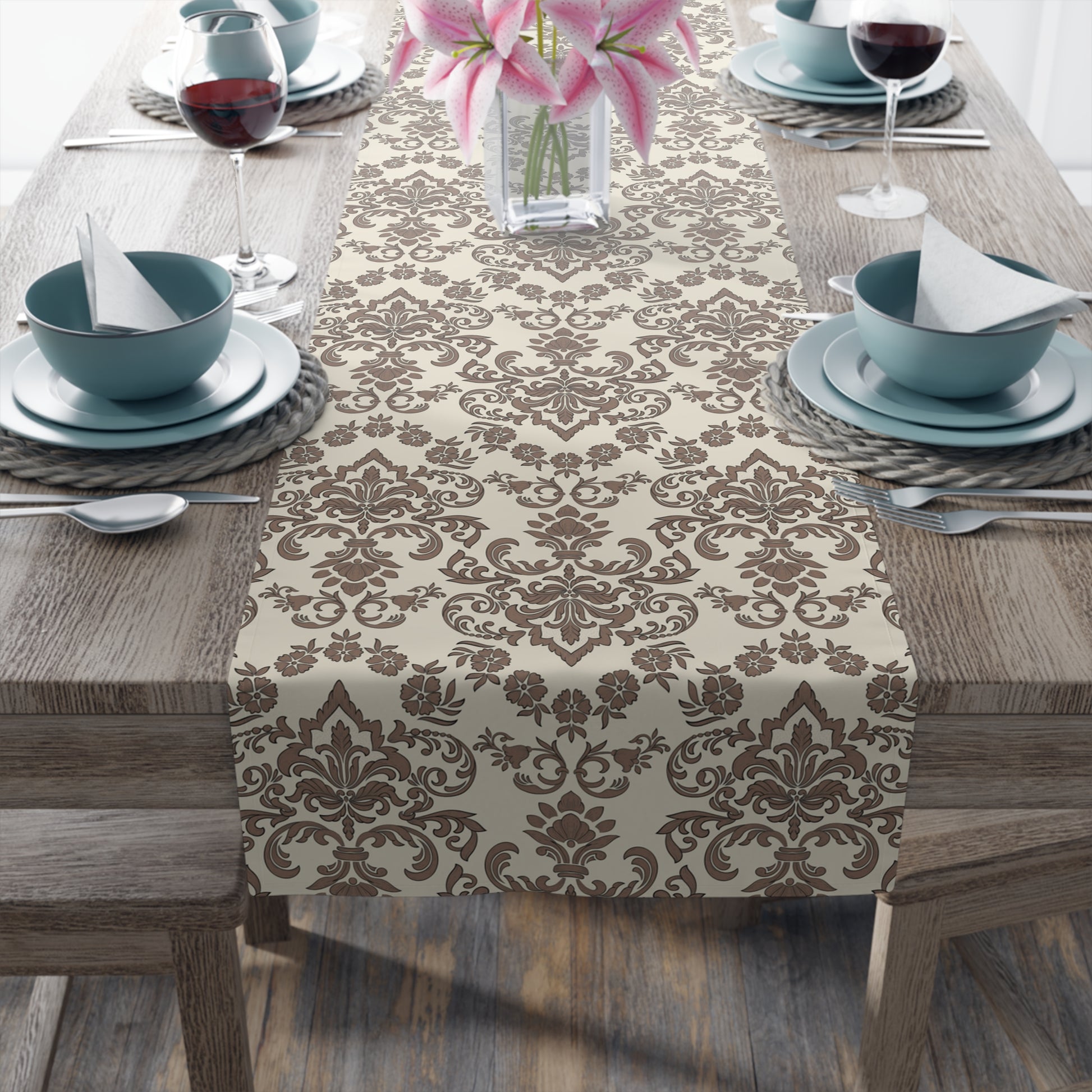 Decorative Baroque Mocha table runner with a brown and beige damask pattern on a wooden table set for dinner.