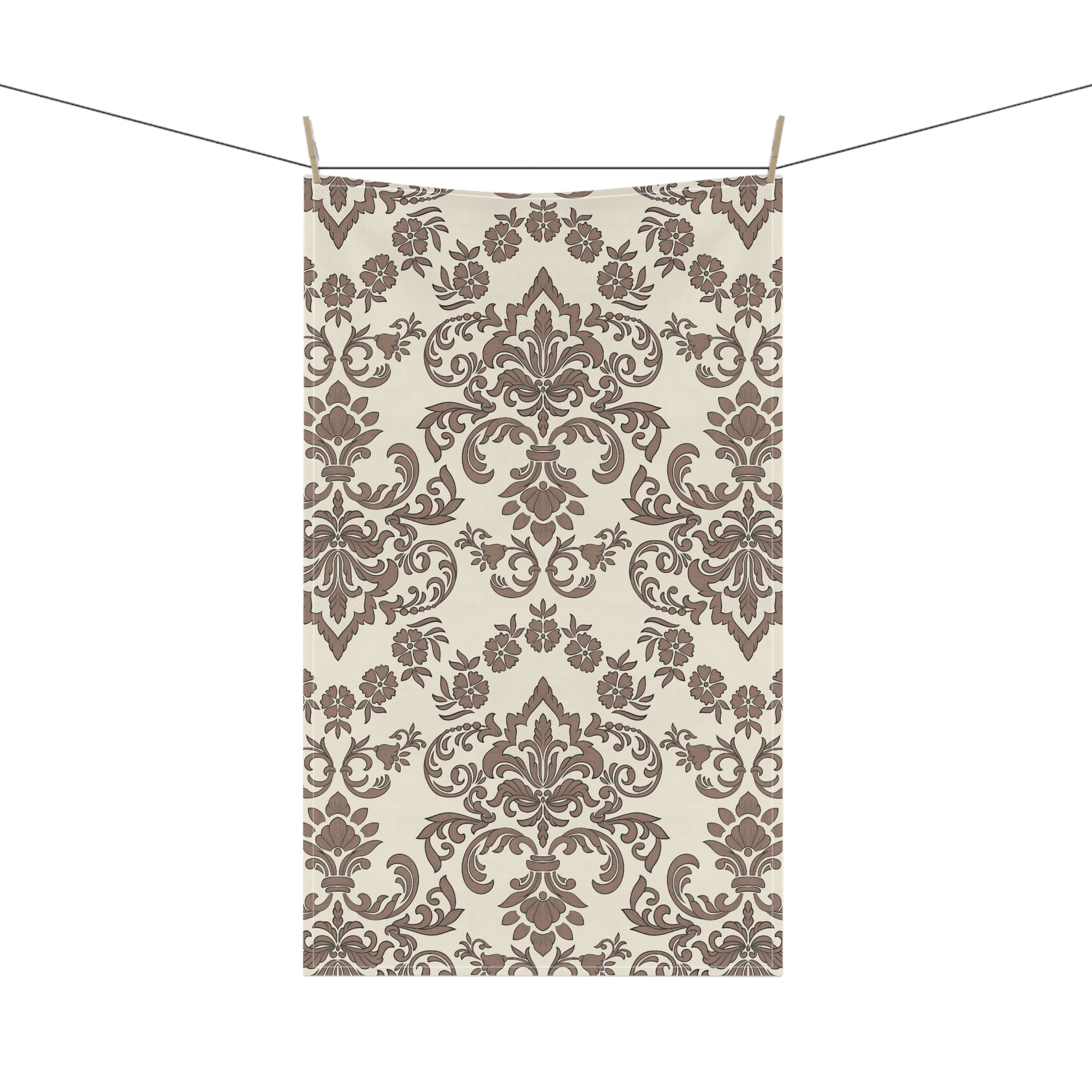 Decorative Baroque Mocha tea towel with brown damask pattern hanging on a line against a white background