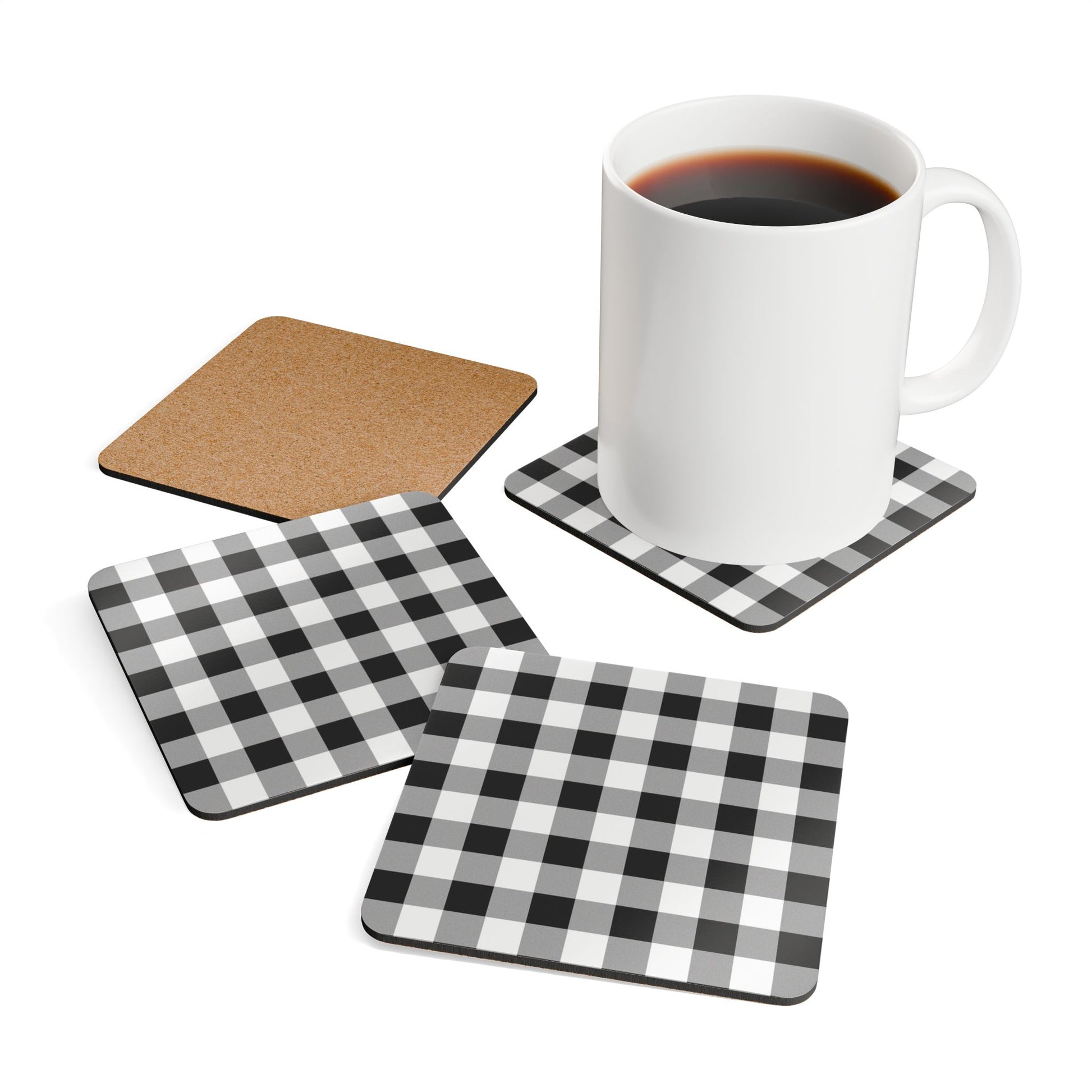 Set of four coasters with black and white gingham patterns including a checkered design, a cork surface, and a plain white surface. A white mug with black coffee is placed on one of the coasters.
