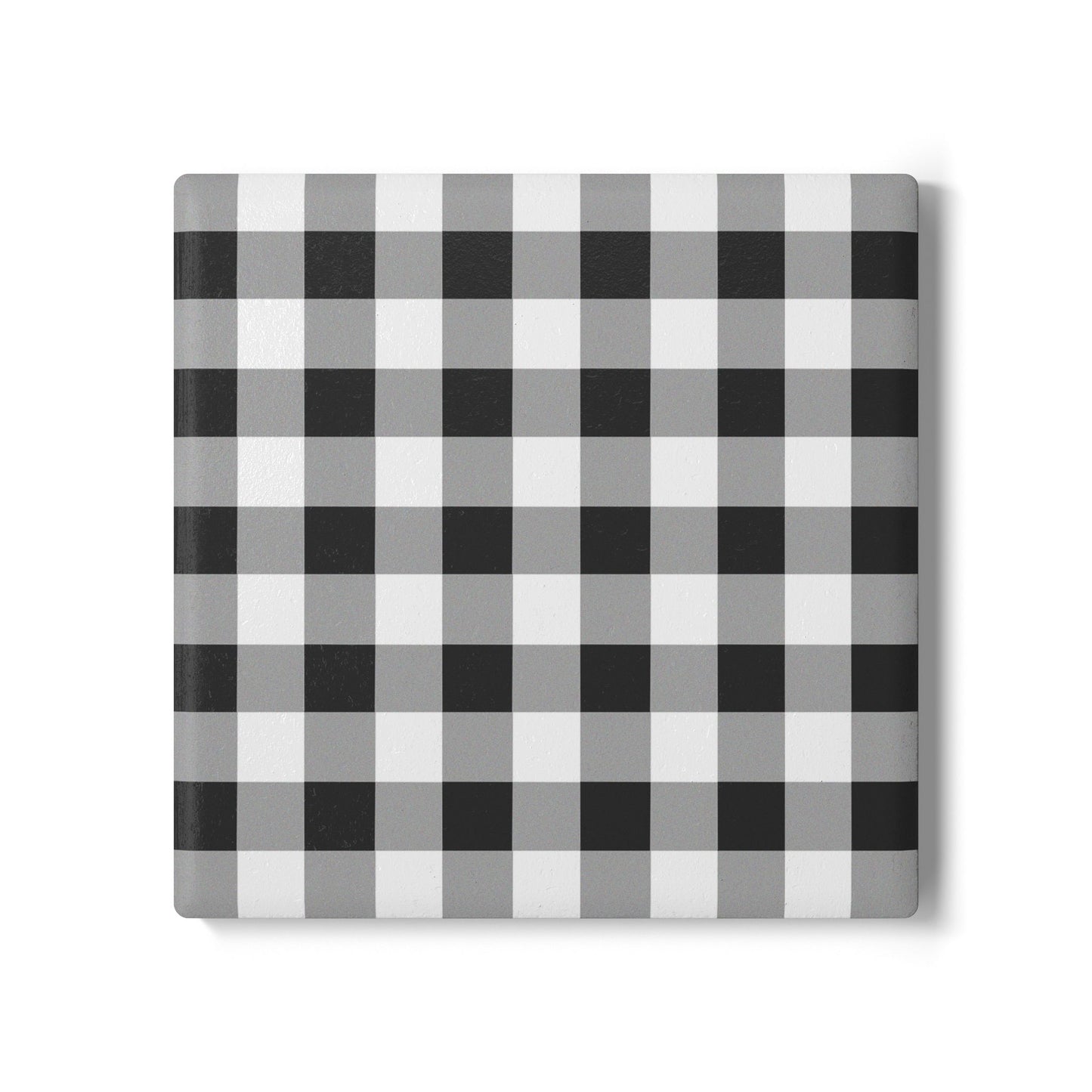 Square checkered black and white gingham patterned tile coaster on a white background