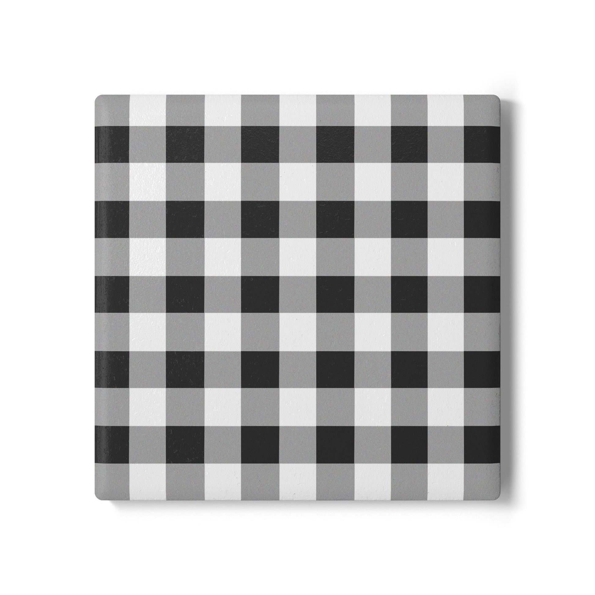 Square checkered black and white gingham patterned tile coaster on a white background
