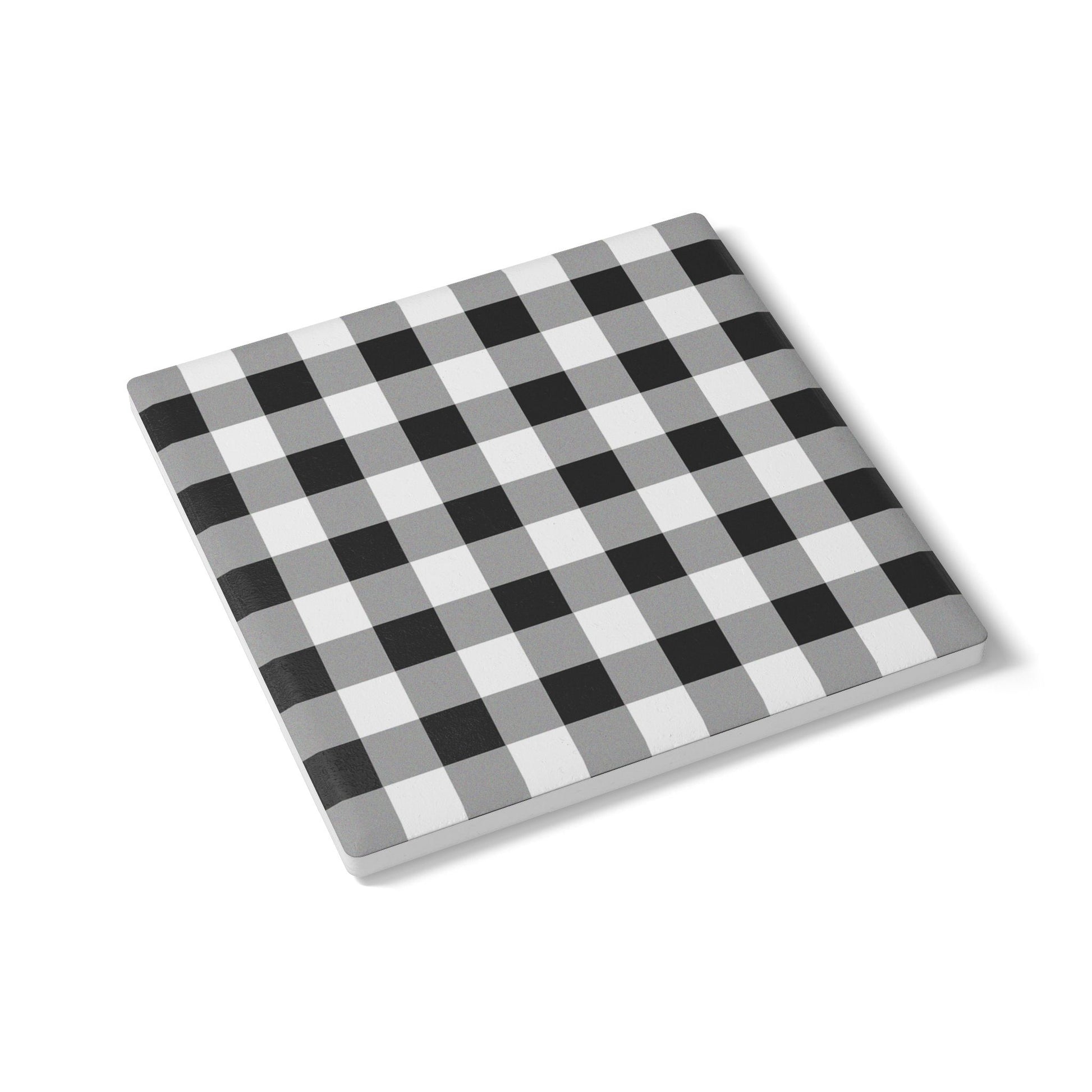 Checkered black and white gingham patterned tile coaster on a white background