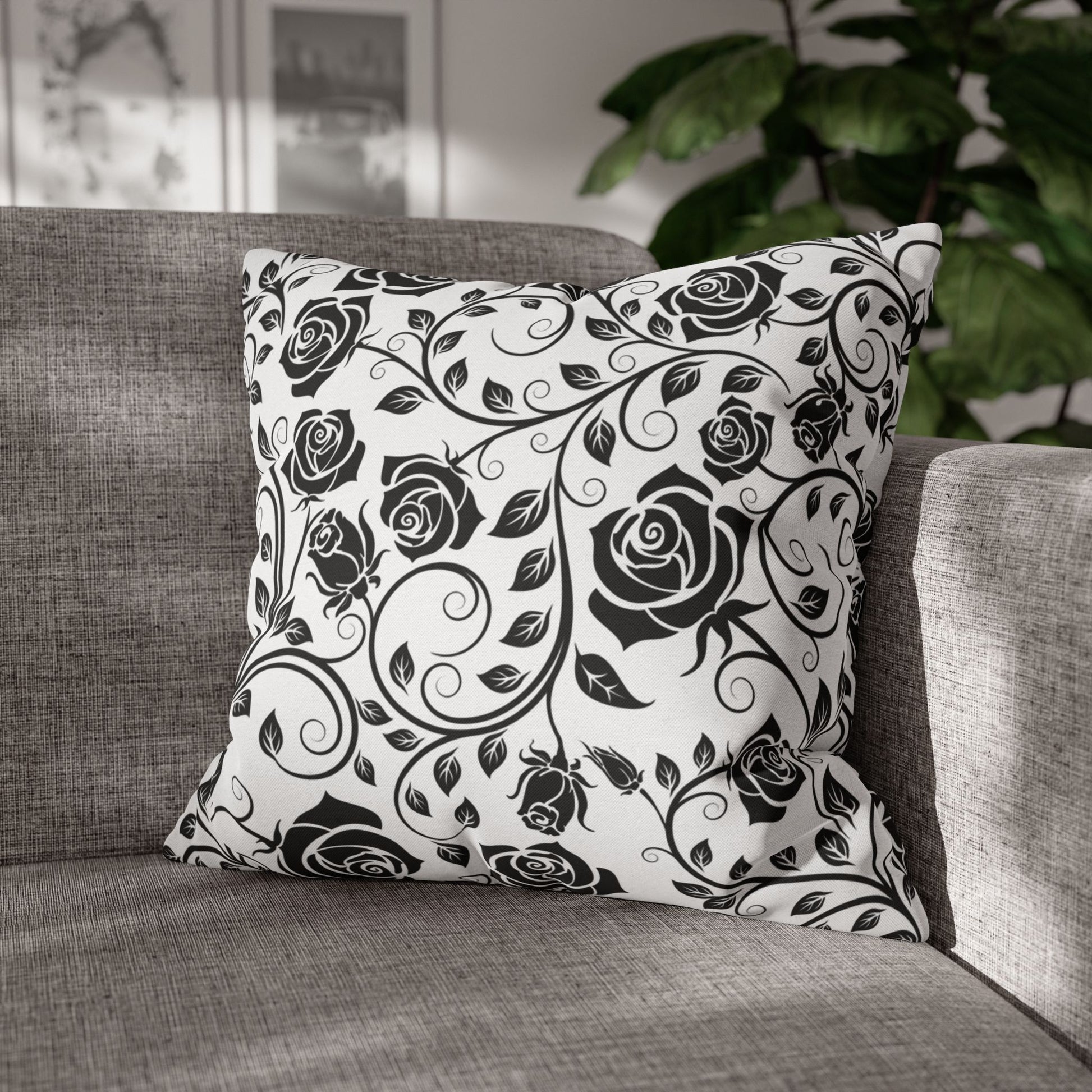 Decorative pillow with black rose pattern on a gray sofa