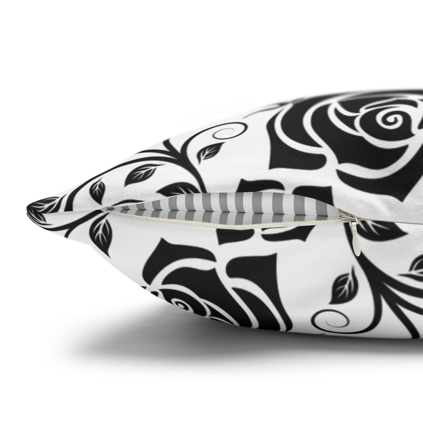 Decorative pillow with black and white rose pattern with zipper closure on a white background