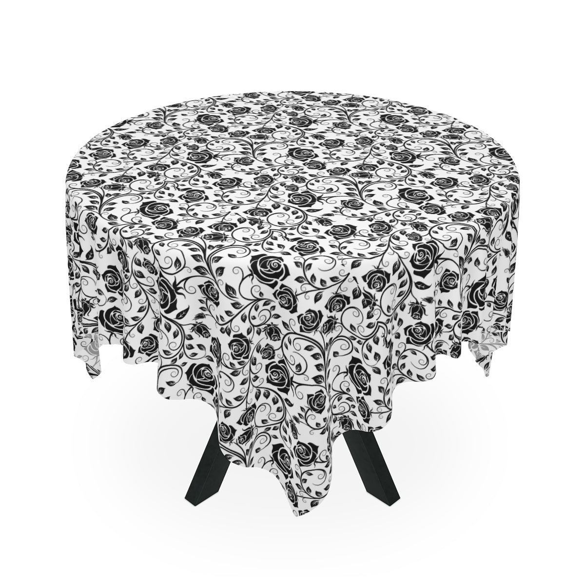 Round table with a black and white floral patterned tablecloth on a white background
