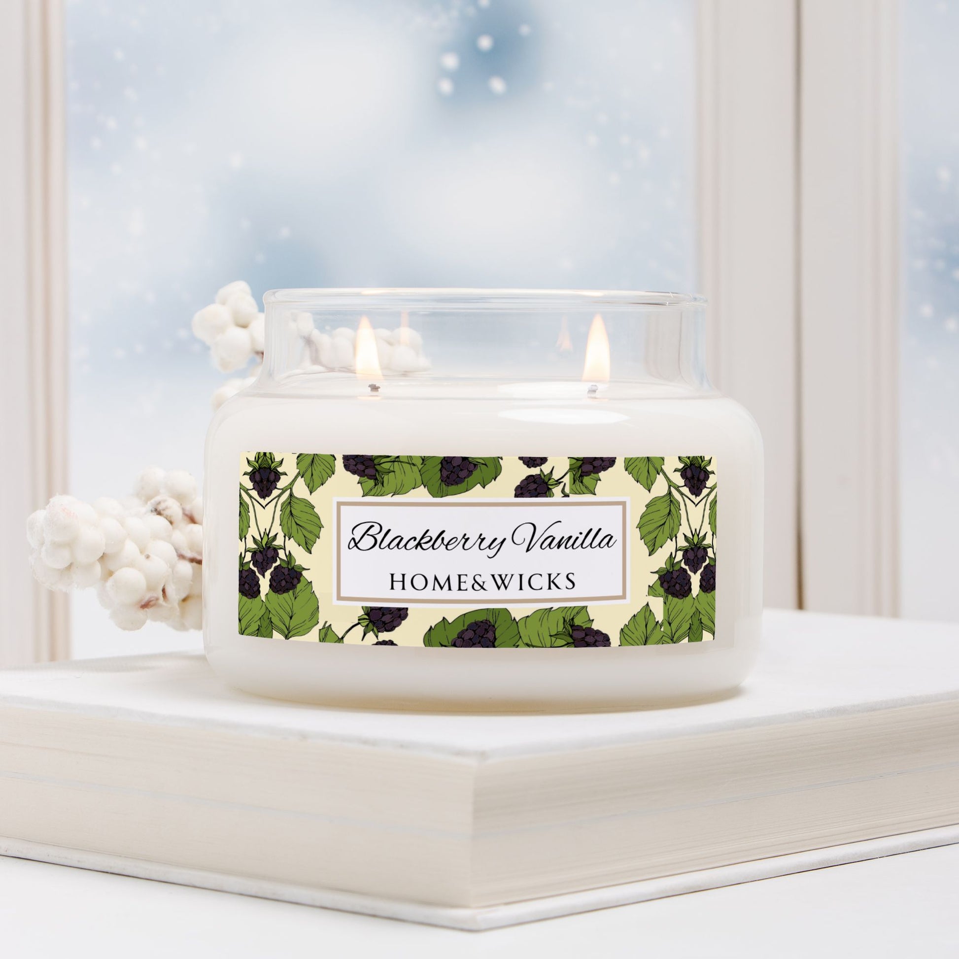 Candle with 'Blackberry Vanilla' label on a windowsill with a snowy background