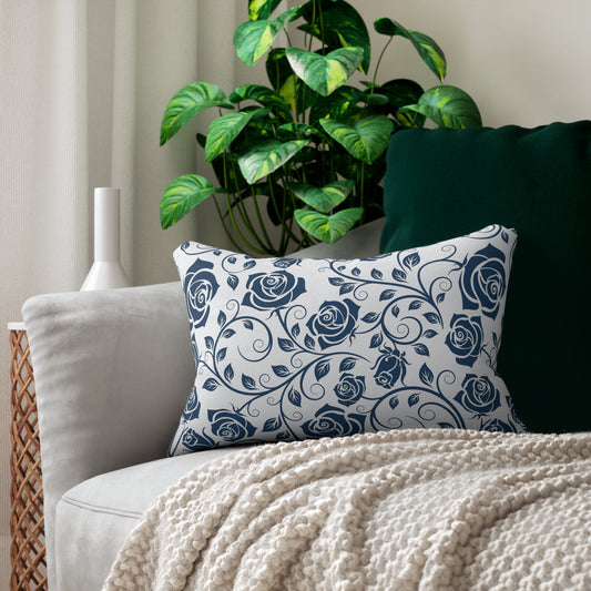 Decorative pillow with blue rose pattern on a sofa with a plant in the background