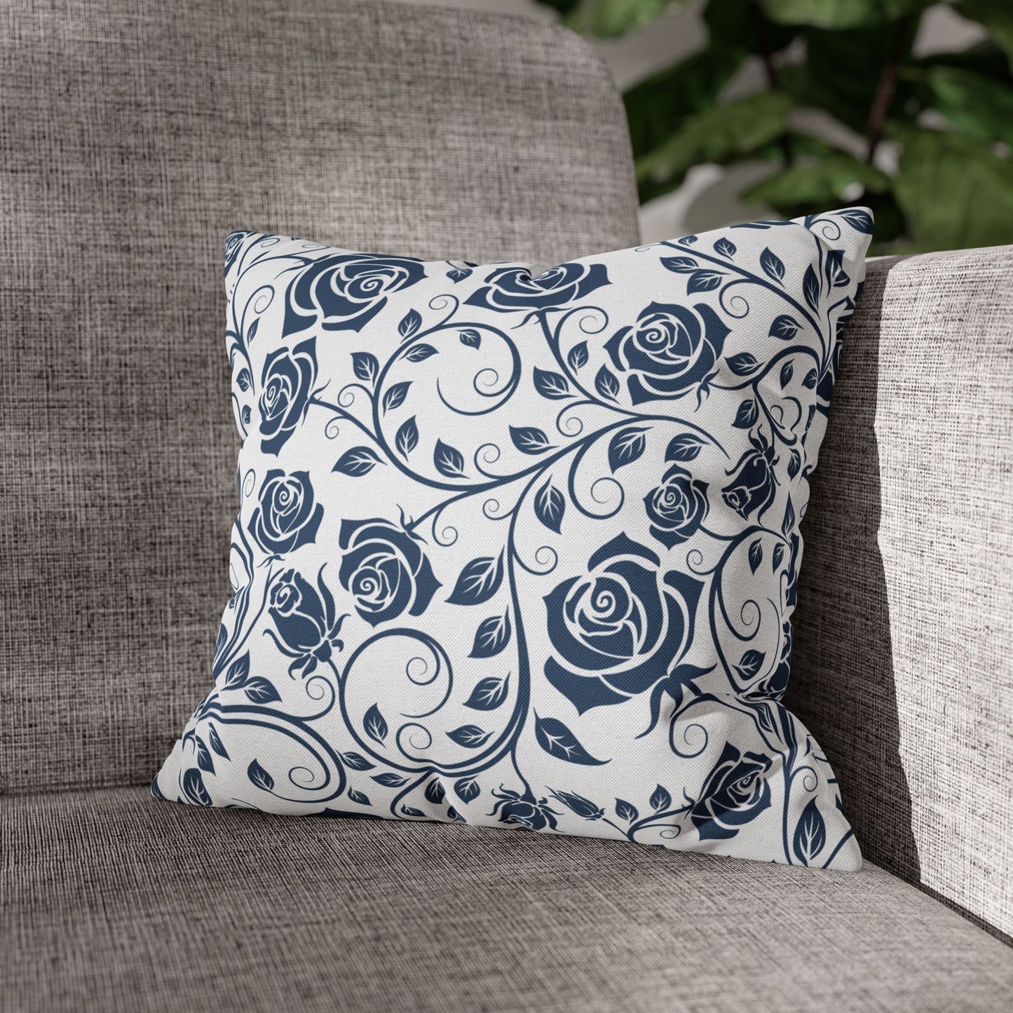 Decorative pillow with blue rose pattern on a gray couch