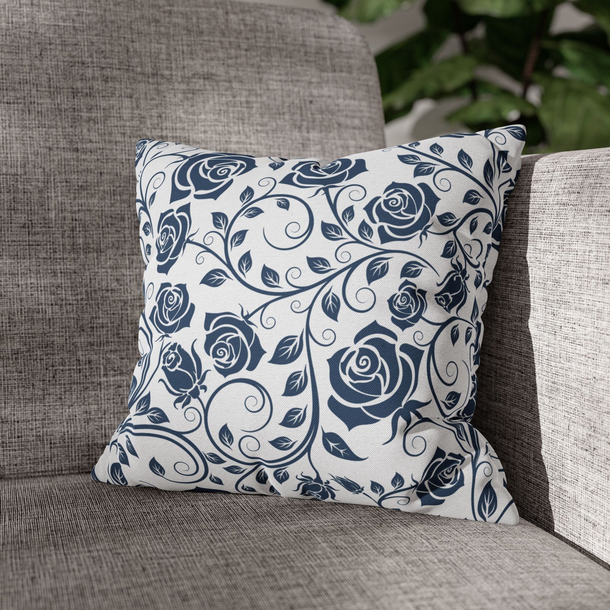 Decorative pillow with blue rose pattern on a gray couch