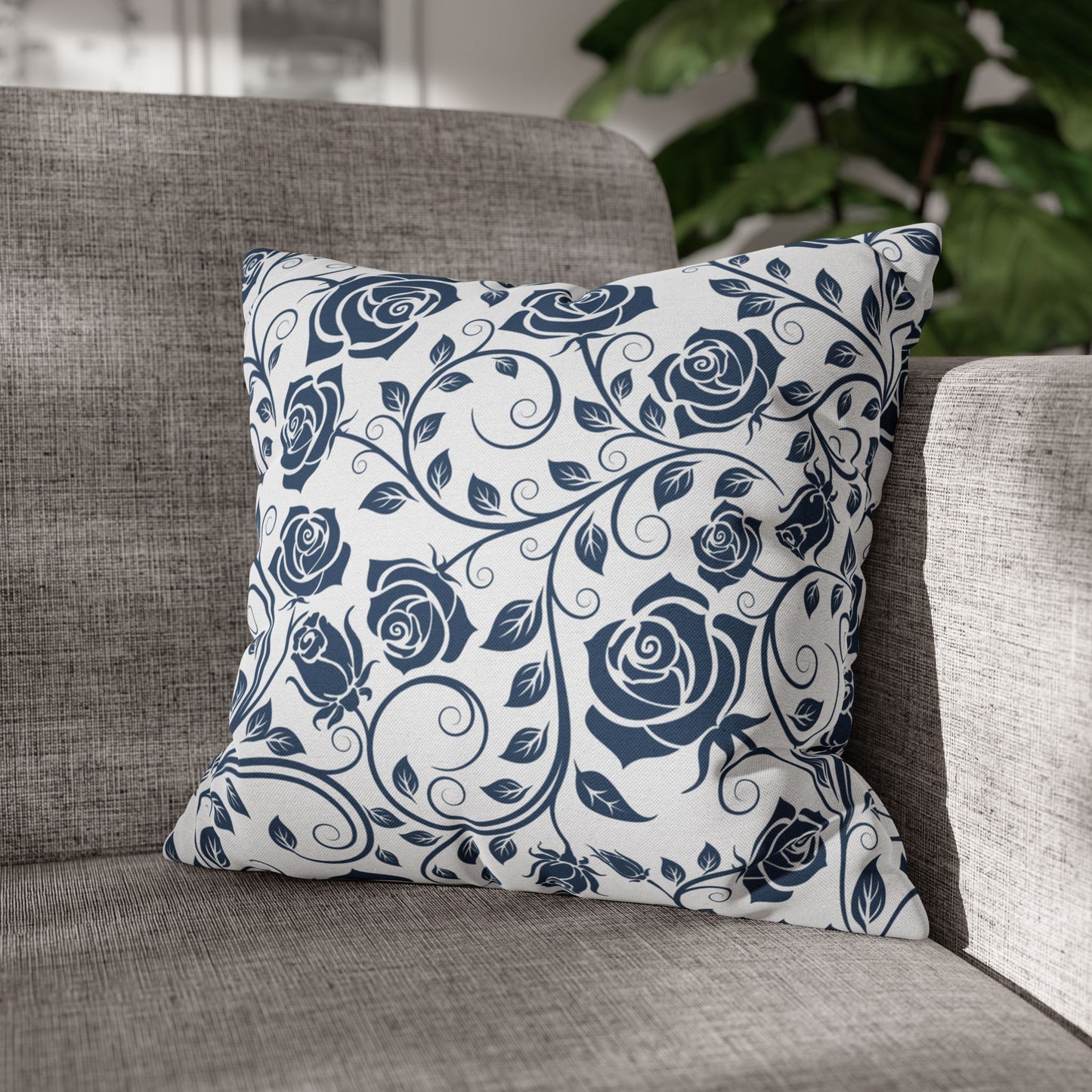Decorative pillow with blue rose pattern on a gray sofa