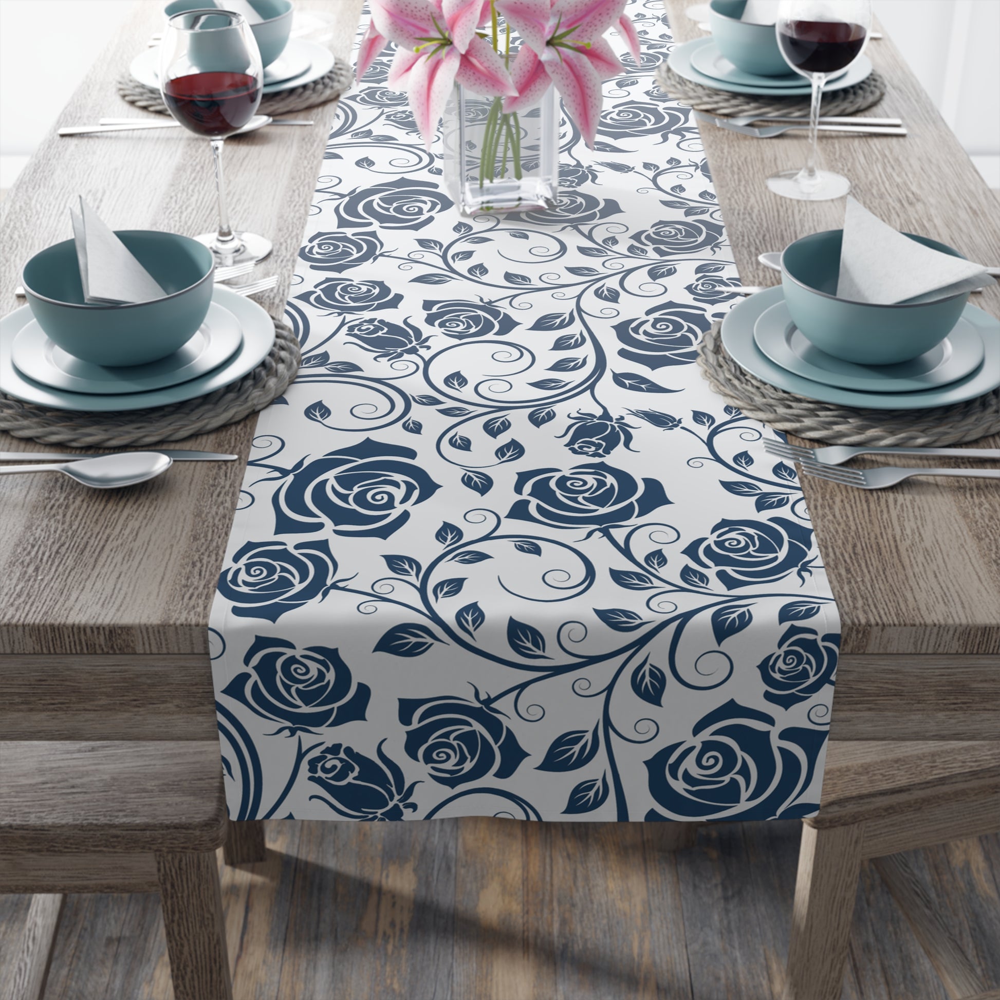 Table setting with a blue floral table runner on a wooden table.