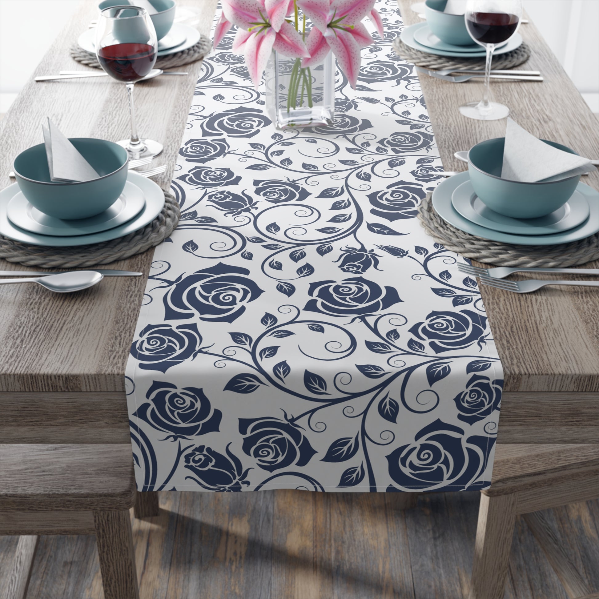 Table setting with a blue floral table runner on a wooden table.