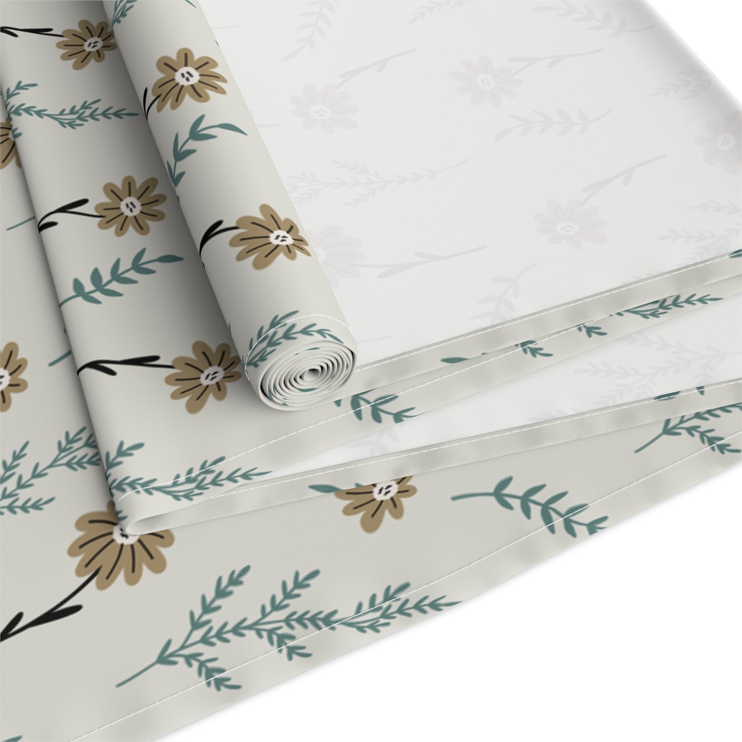 Our Brown Chamomile table runner that is rolled and has a brown and gray floral-pattern on the table runner fabric with brown and green flowers on a white background