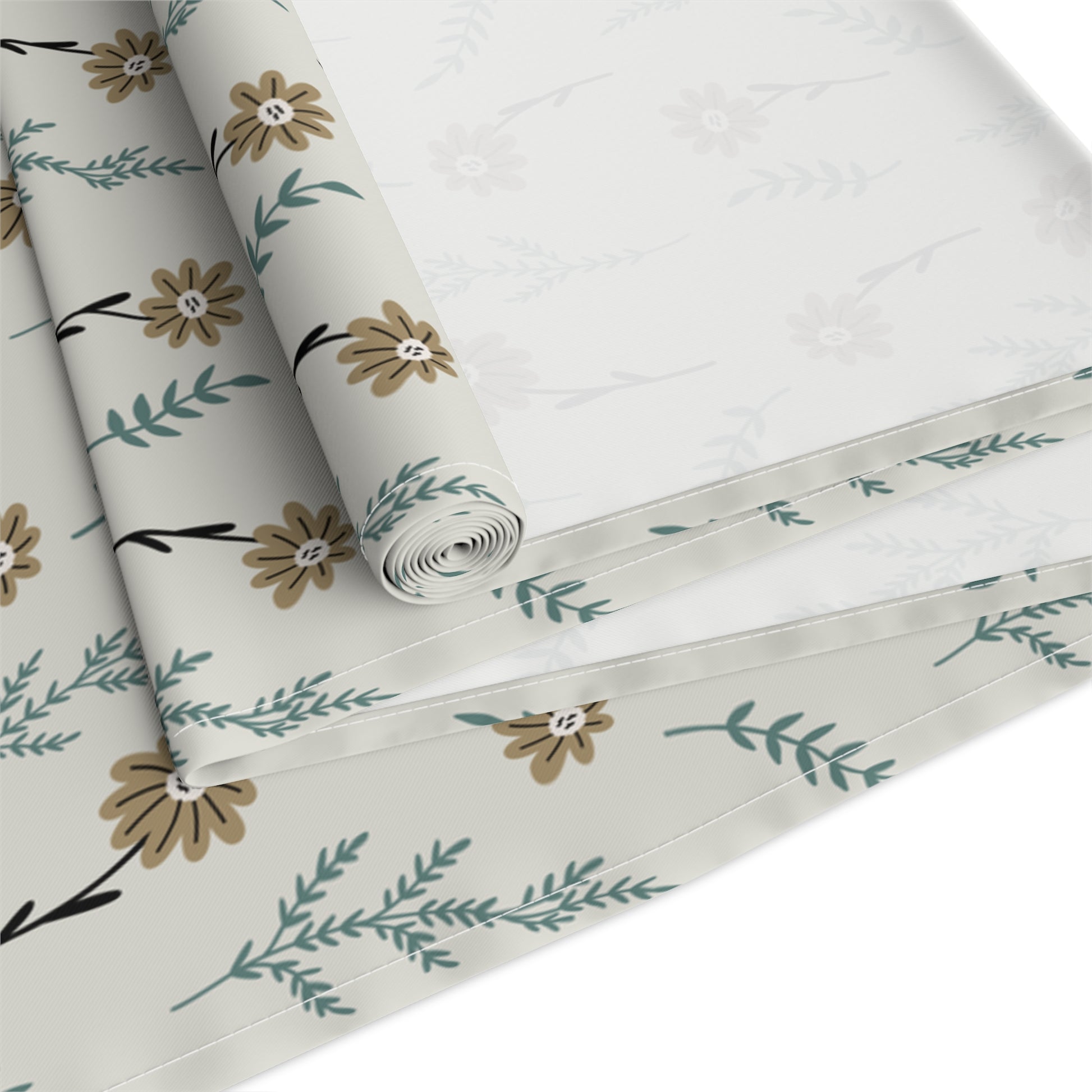 Our Brown Chamomile table runner that is rolled and has a brown and gray floral-pattern on the table runner fabric with brown and green flowers on a white background