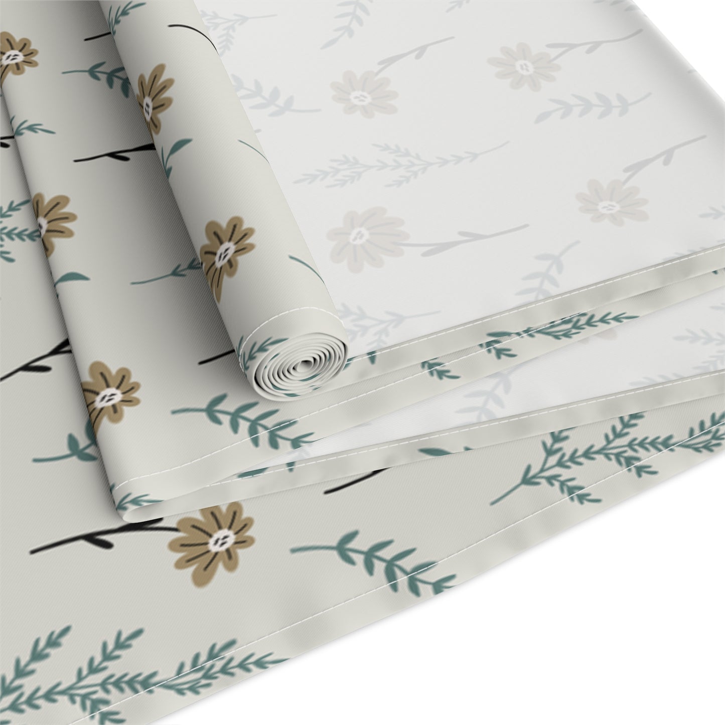 Our Brown Chamomile table runner rolled that has a brown and gray floral-pattern on the table runner with flowers and leaves on a white background