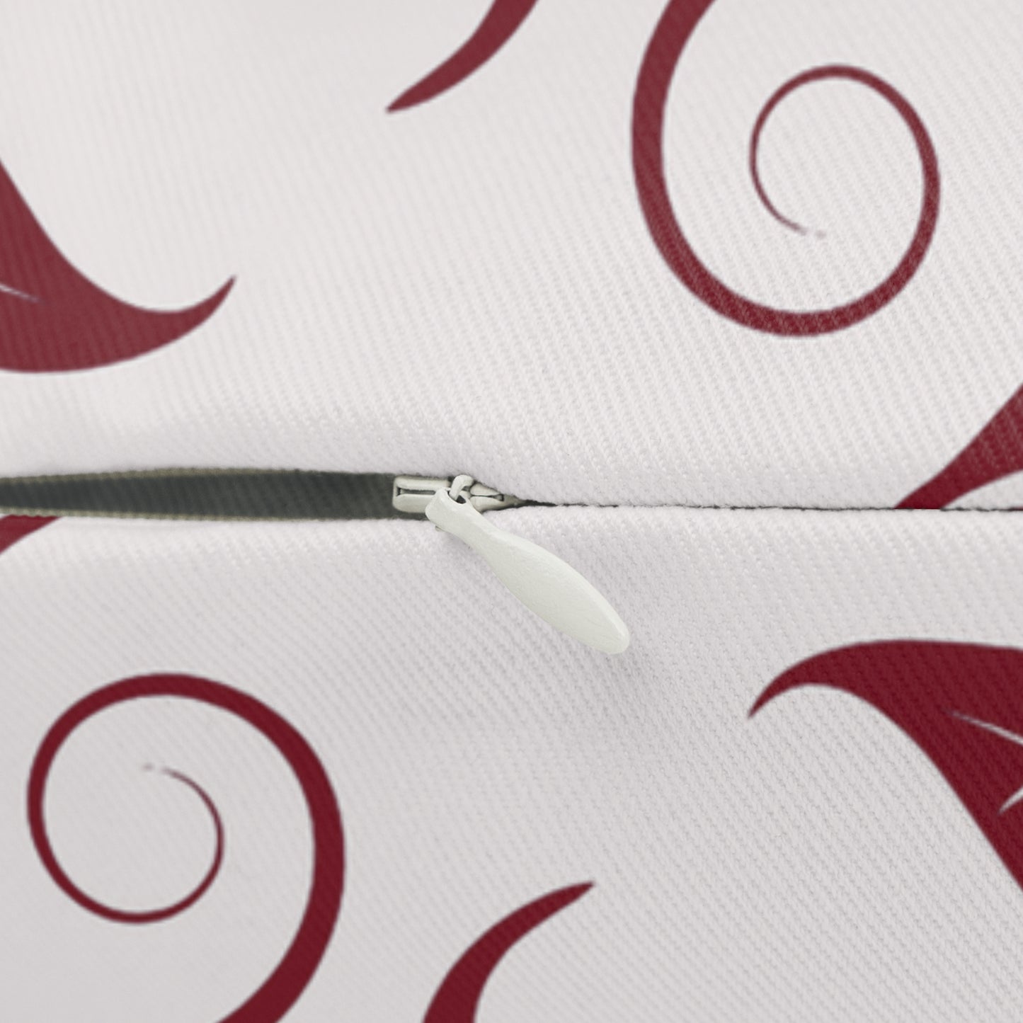 Pillow with burgundy red swirl patterns and a zipper on a white background