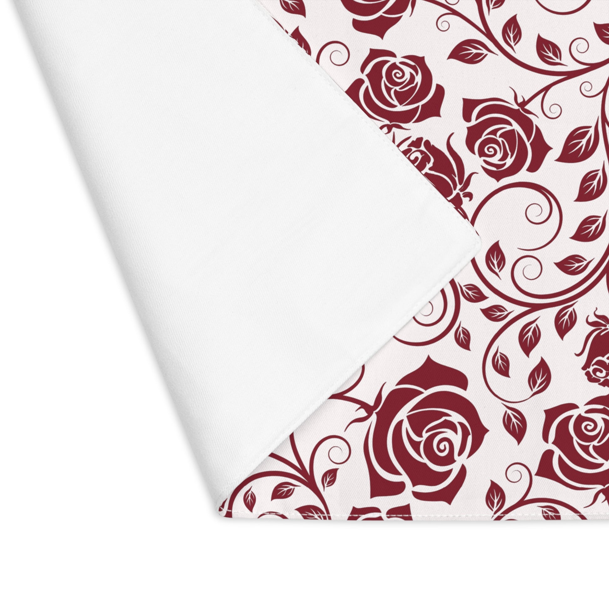 Red rose pattern placemat with corner folded over to reveal white backside