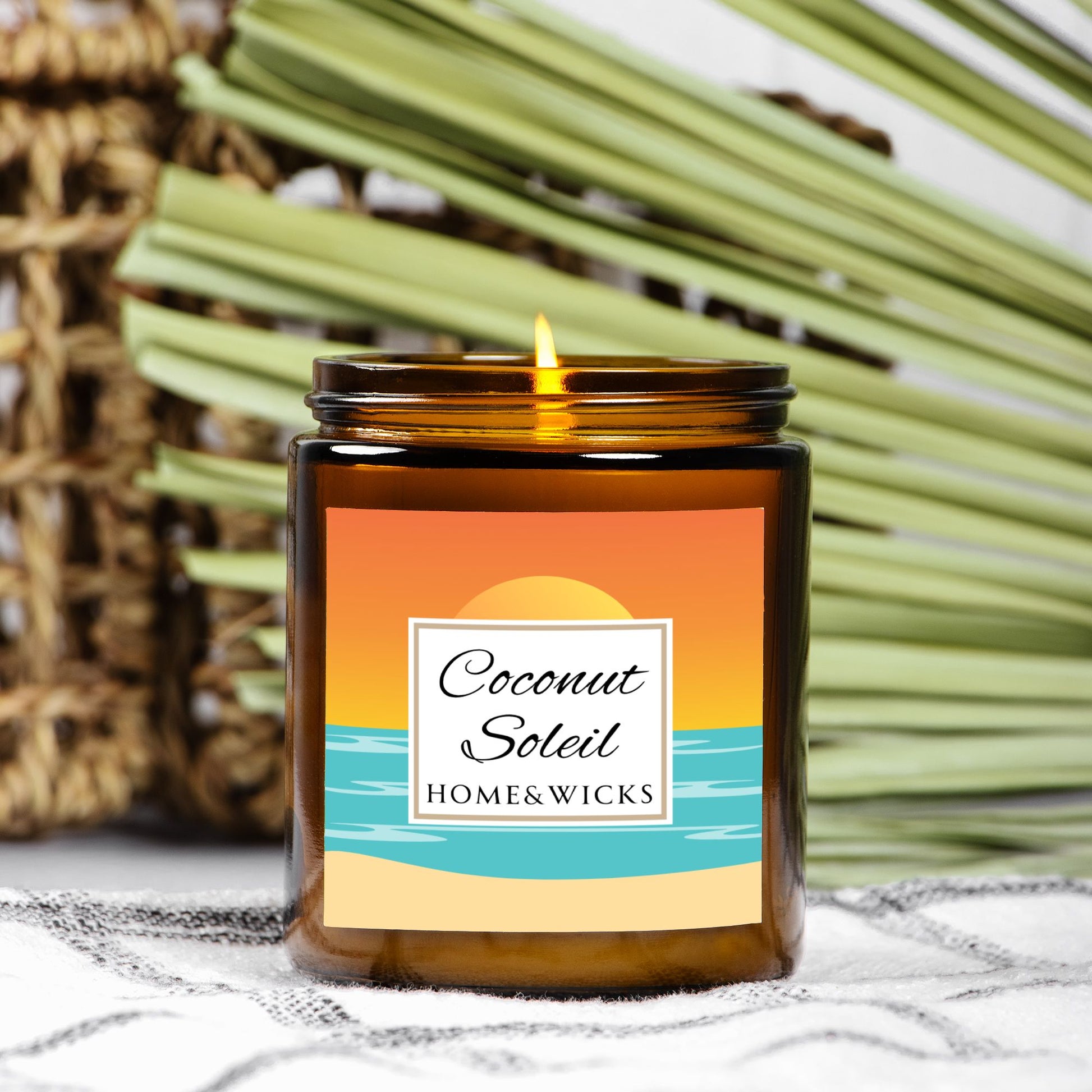 Coconut Soleil coconut apricot wax candle in an amber jar with gold lid with a colorful ocean sunset graphic label featuring 'Coconut Soleil' by Home & Wicks on a white background on a textured surface with palm leaves in the background