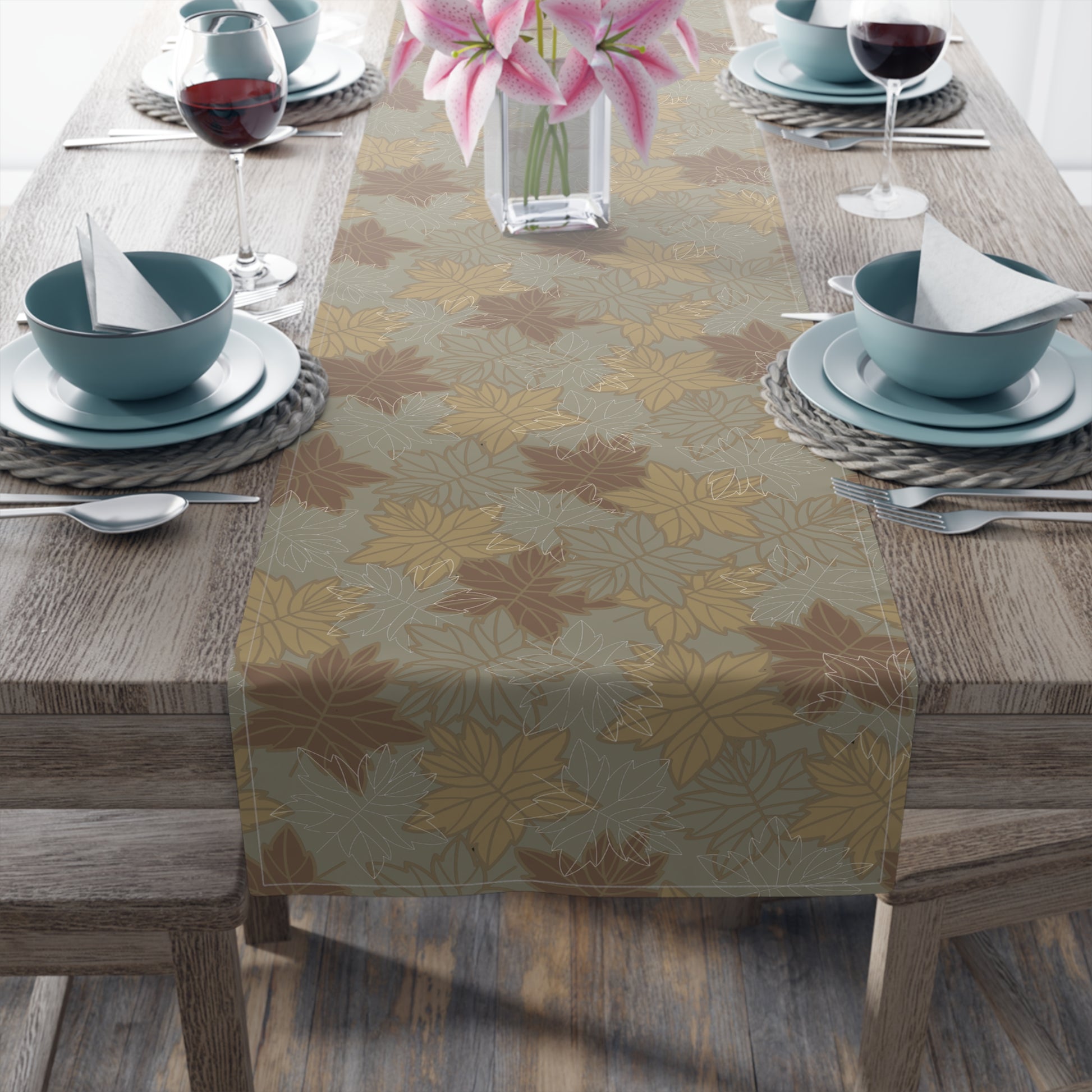 Table setting with a fall leaf-patterned table runner on a wooden table.