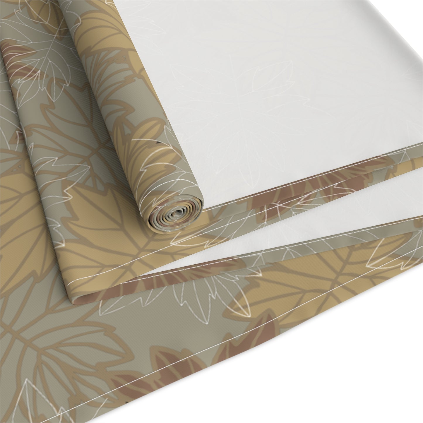 Roll of decorative table runner with leaf pattern on a white background