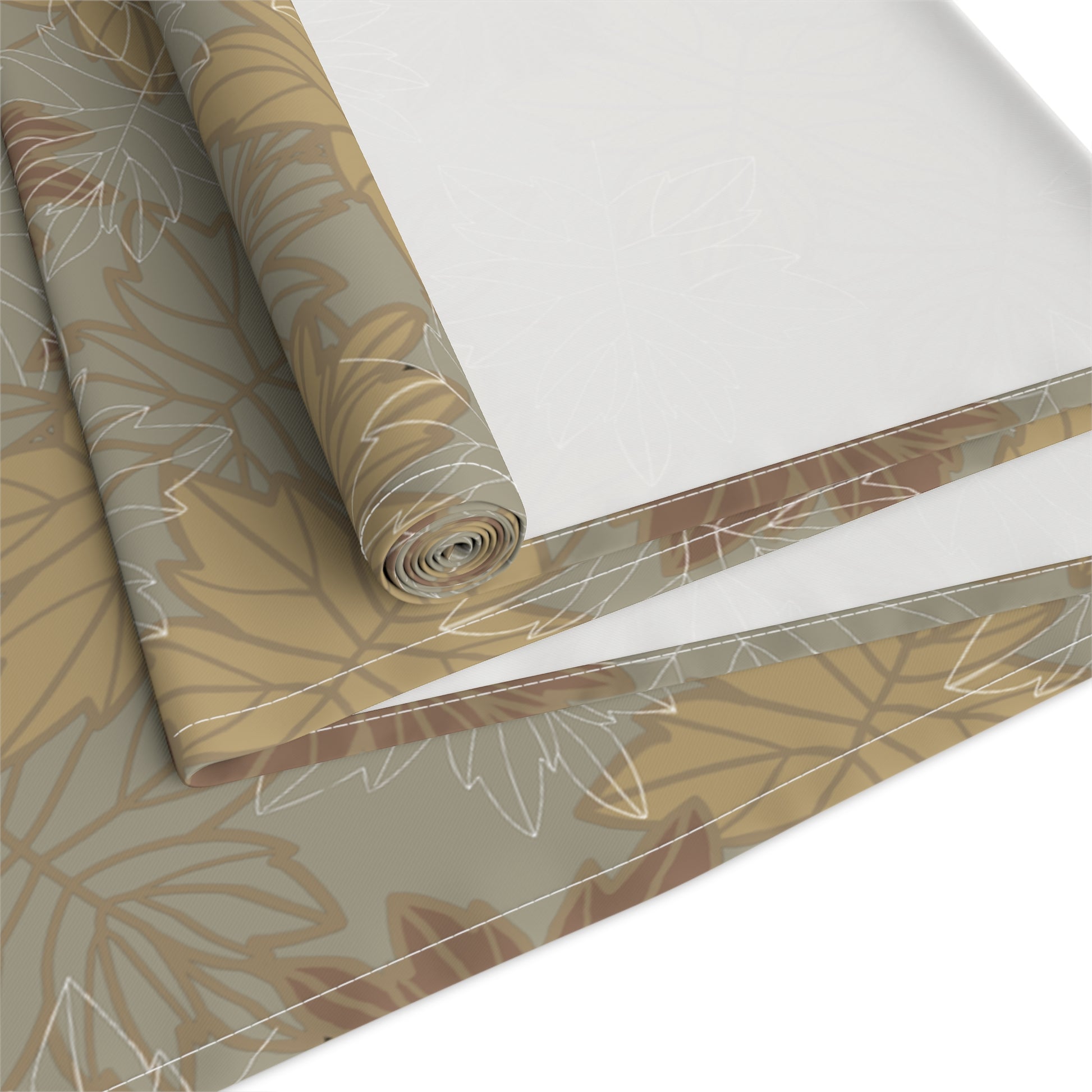 Roll of decorative table runner with leaf pattern on a white background