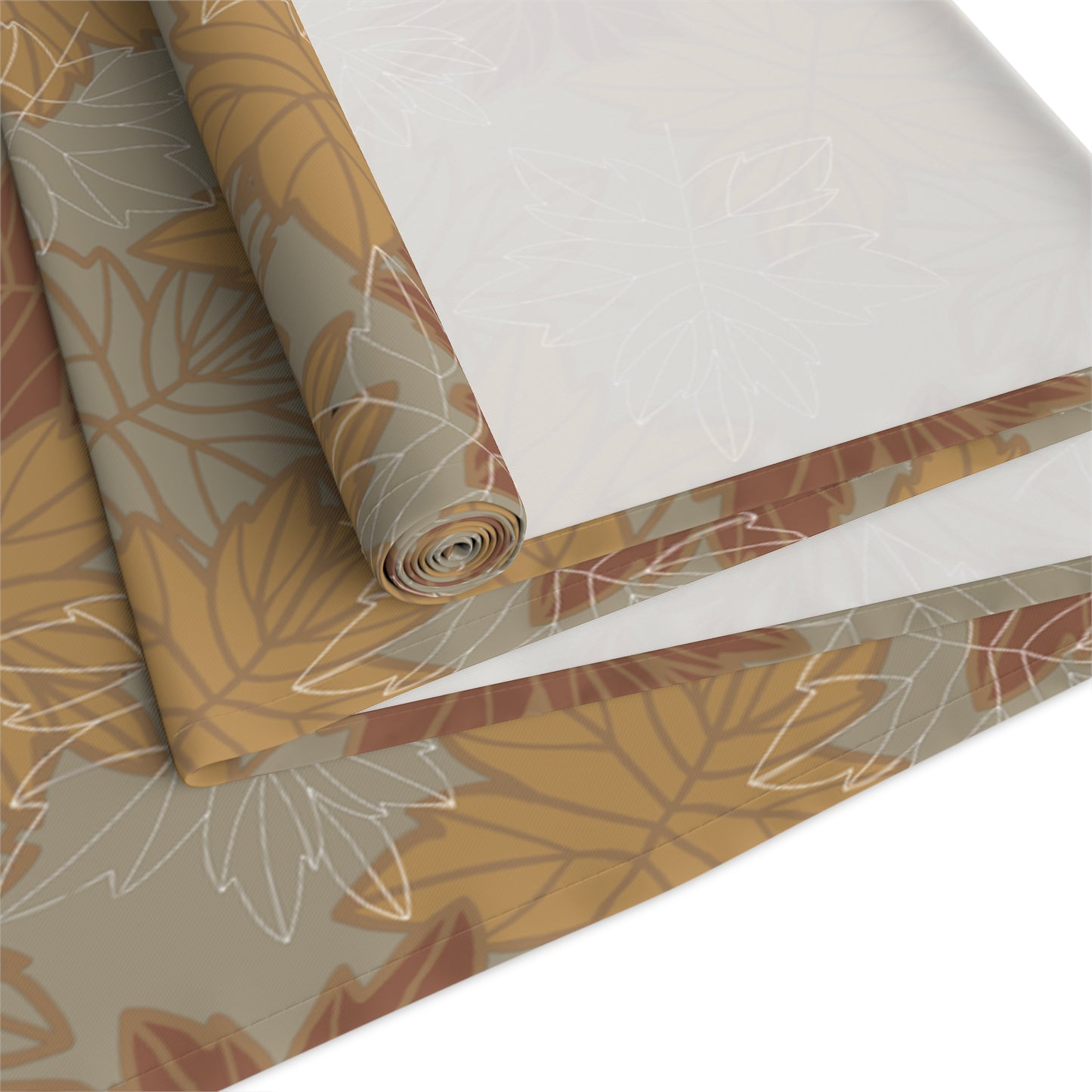 Roll of decorative table runner with leaf pattern on a white background