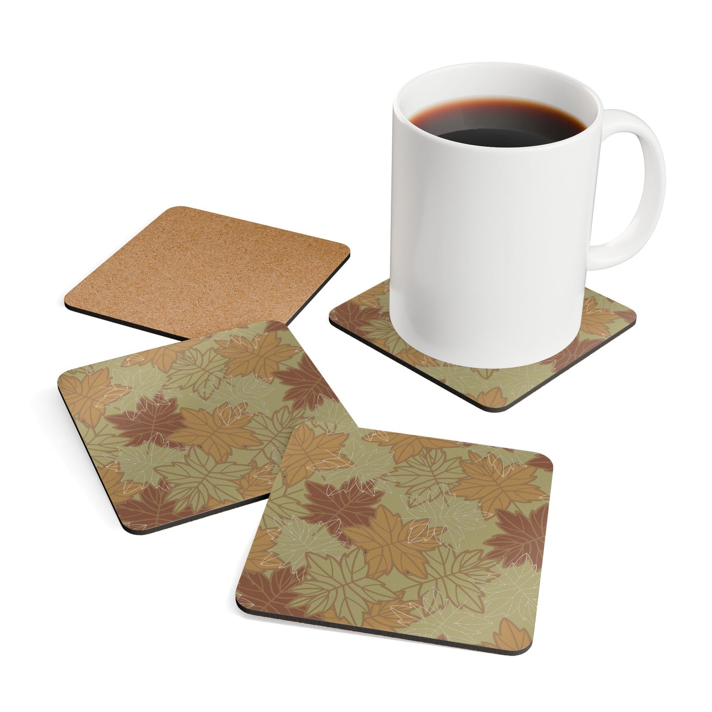 Set of four coasters with earthy colored leaf pattern and a white mug with coffee on a white background