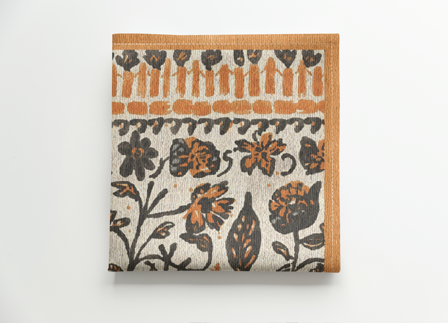 Fall Flowers cloth napkin, with a boho orange and black floral pattern, is printed on a cotton twill reusable napkin fabric, folded on a white background 