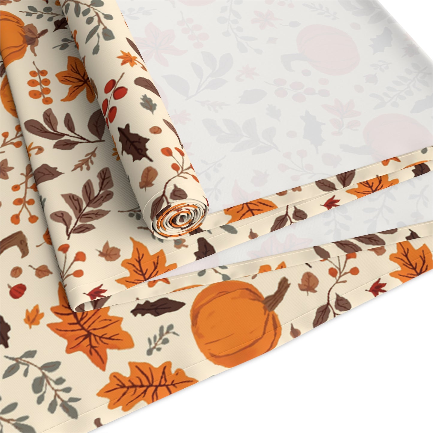 Fall Leaves and Pumpkins table runner has brown and orange fall leaves with orange pumpkins with beige background printed on the table runner fabric shown rolled up and folded on a white background.
