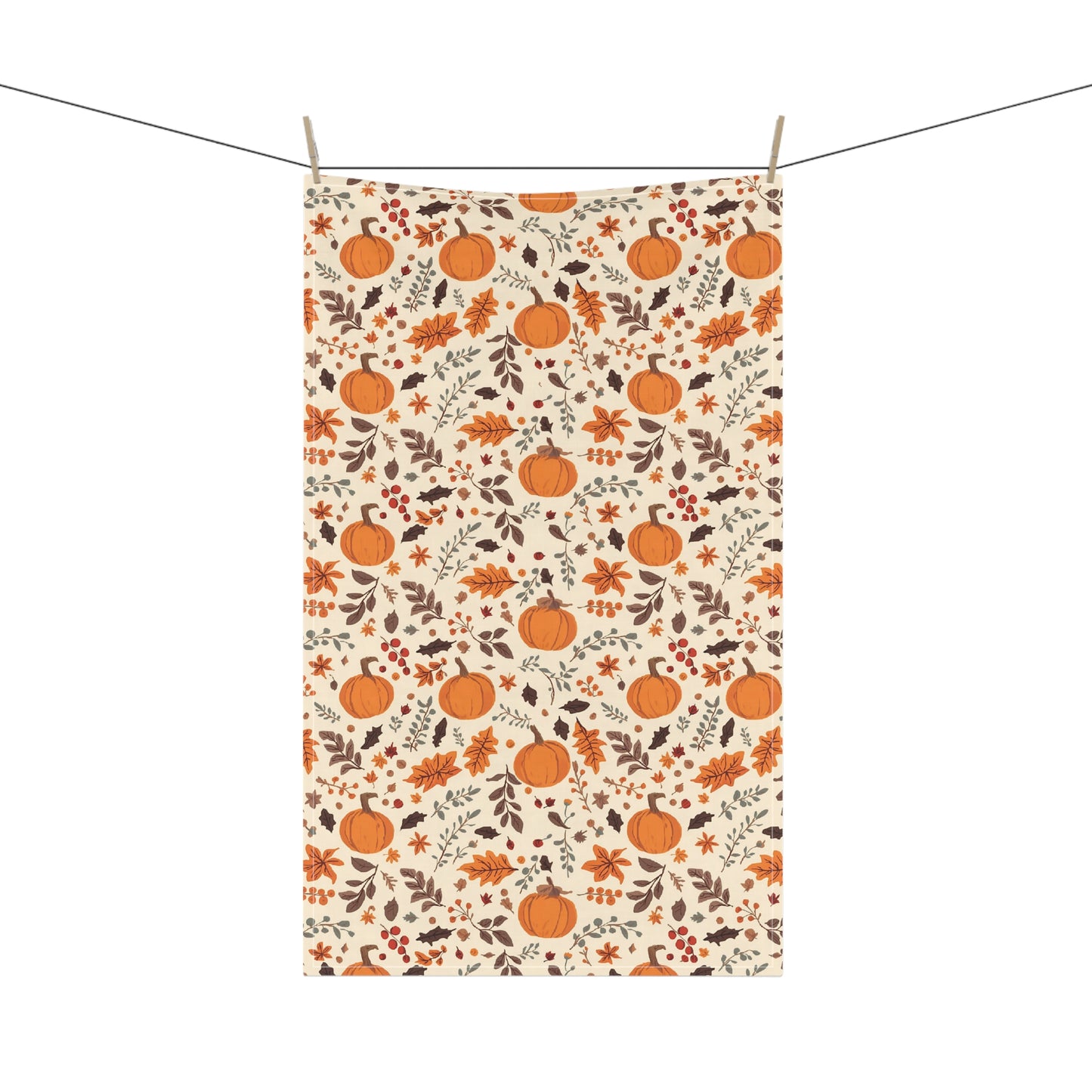 Tea kitchen towel with pumpkin and leaf pattern hanging on a line