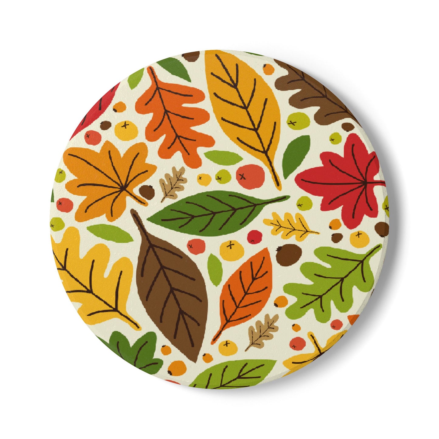 Round ceramic tile coaster with autumn leaf pattern on top of tile coaster on a white background