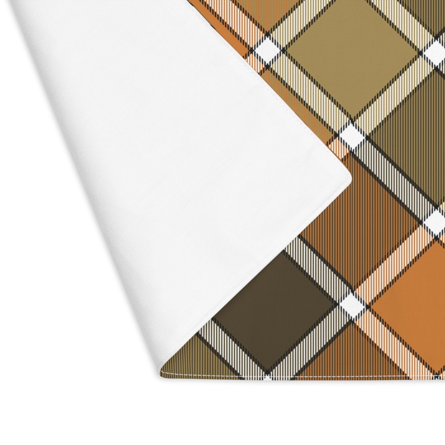 Fall Plaid placemat has plaid patterned colors with brown, orange, and green colors. The placemat's corner is folded over to reveal the white back and sits on a white background.