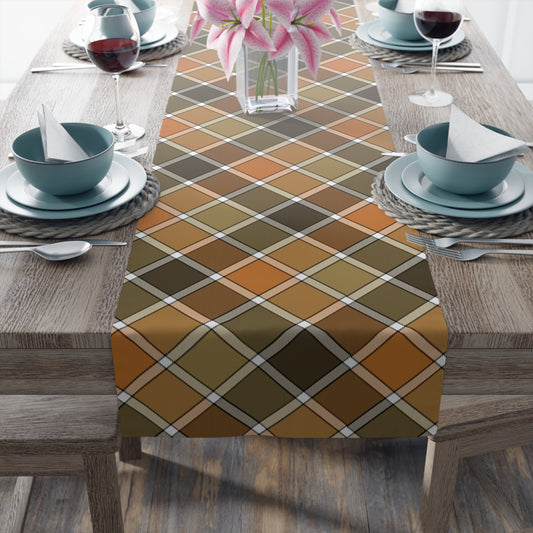 Our Fall Plaid table runner has brown, green, orange plaid patterned colors. The table runner is on a dining table with glasses, and plates.