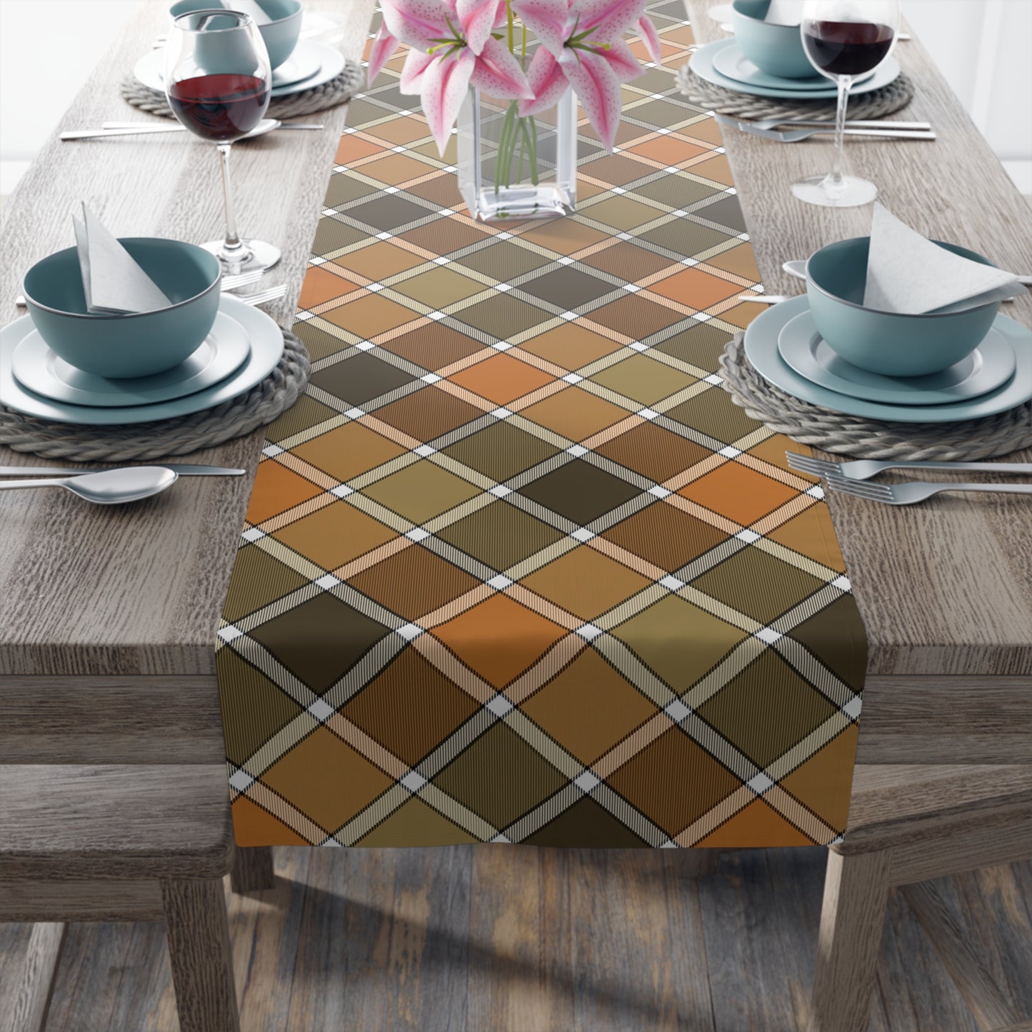 Our polyester Fall Plaid table runner has a brown, green, orange table runner patterned colors on a dining table with bowls, and glasses on a wooden table.