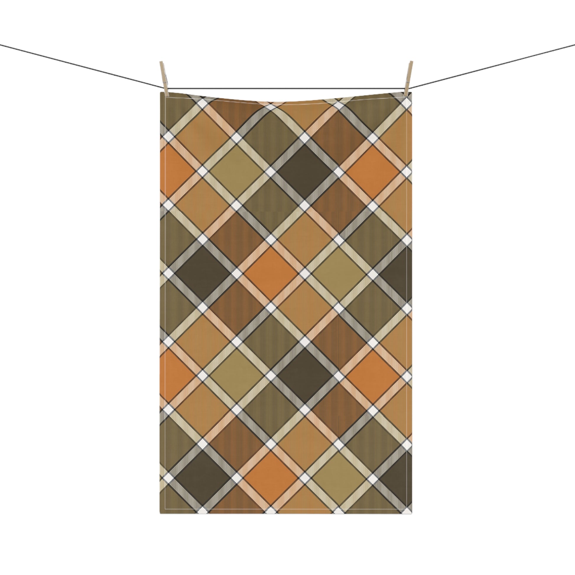 Green, orange and gold plaid patterned kitchen tea towel hanging on a line with a white background