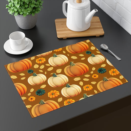 Fall Pumpkins placemat with pattern of pumpkins and leaves on a brown background printed on front of placemat, on a dark table with tea set and plant.