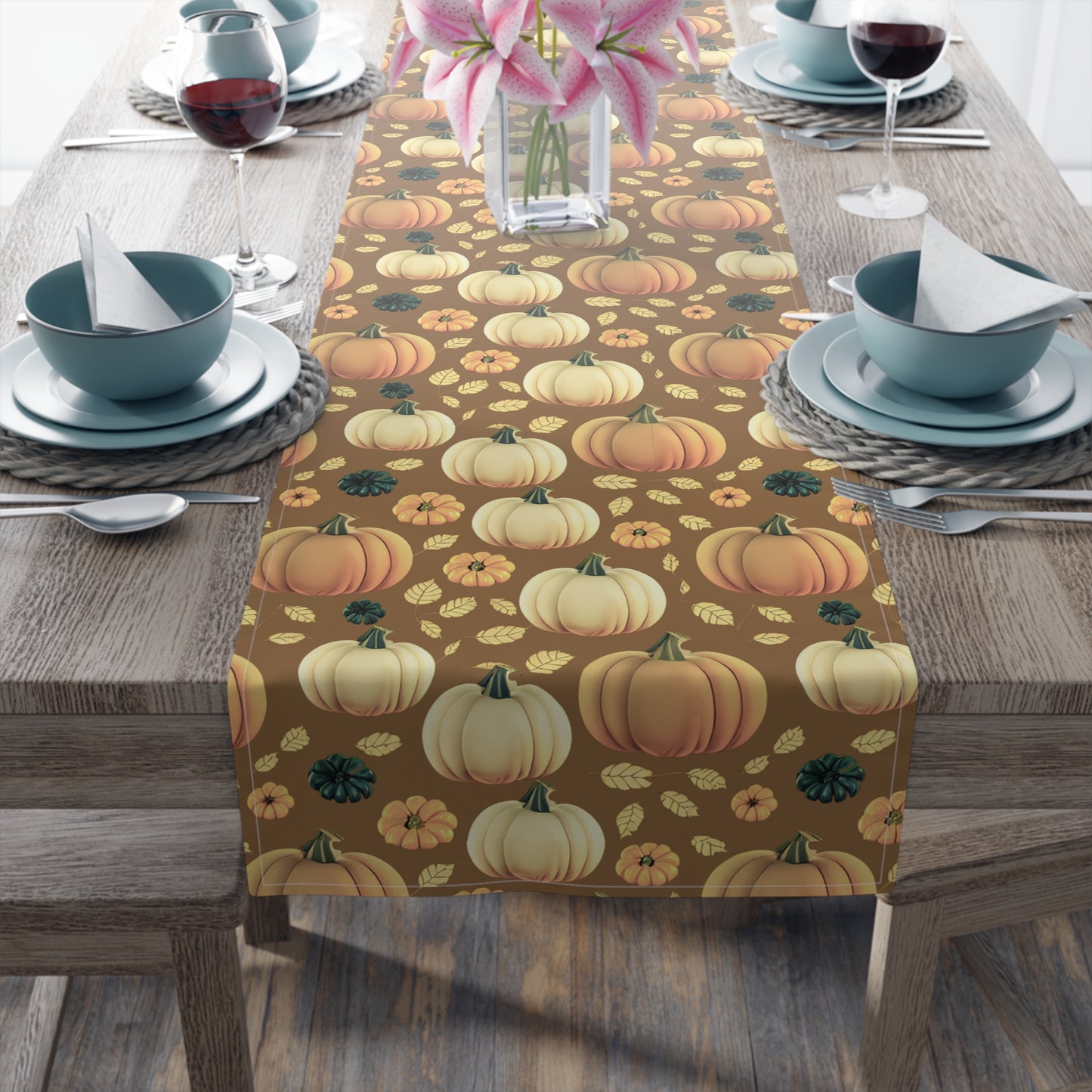 Fall Pumpkins table runner with a pumpkin-themed pattern printed on front of table runner on a table setting with a pumpkin patterned table runner on a wooden table.