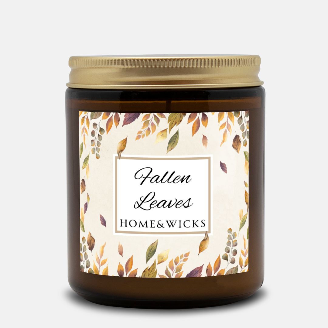 Amber candle jar with gold lid and 'Fallen Leaves' label on a white background