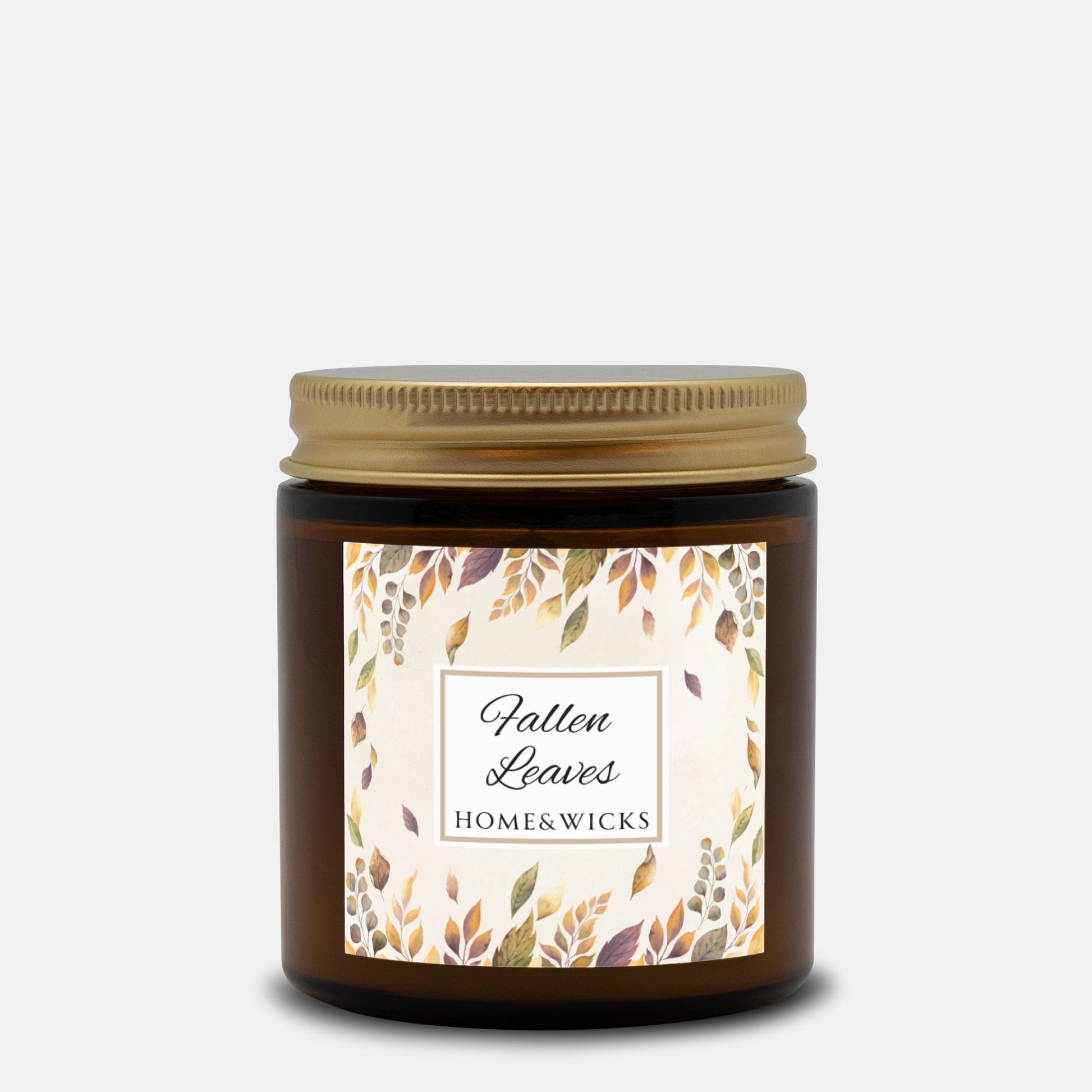 Amber candle jar with gold lid and 'Fallen Leaves' label on a white background