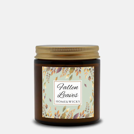 Fallen Leaves candle in a 4 oz. amber glass jar with gold lid with a 'Fallen Leaves' label on a white background by Home & Wicks