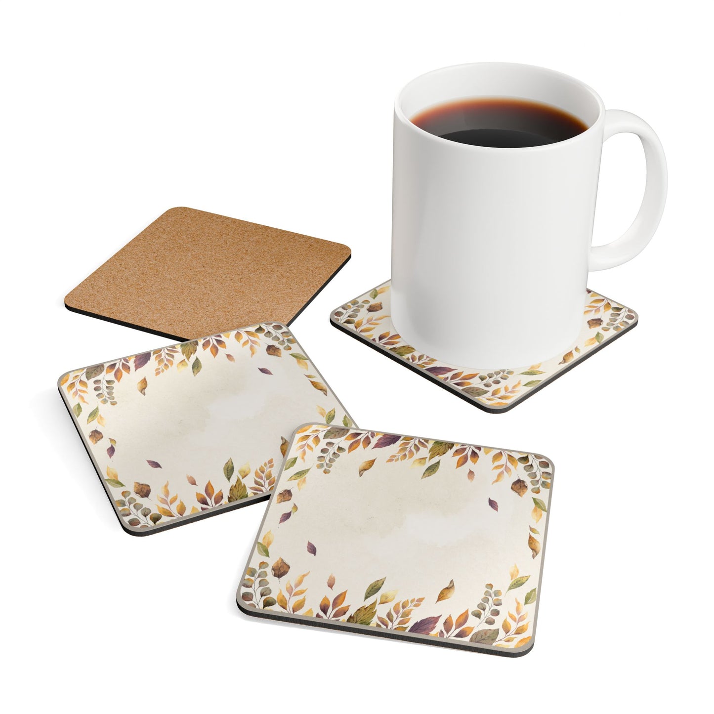 Set of four fallen leaves coasters with leaf patterns and a white mug with coffee on a white background