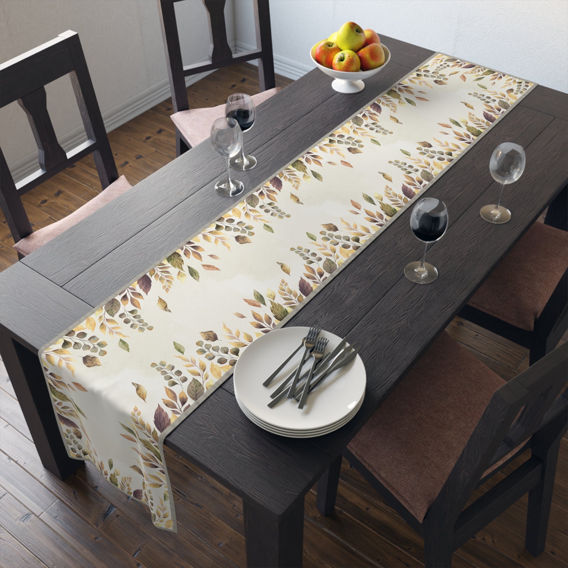 Dining table with a Fallen Leaves patterned table runner, plates, and glasses in a room.