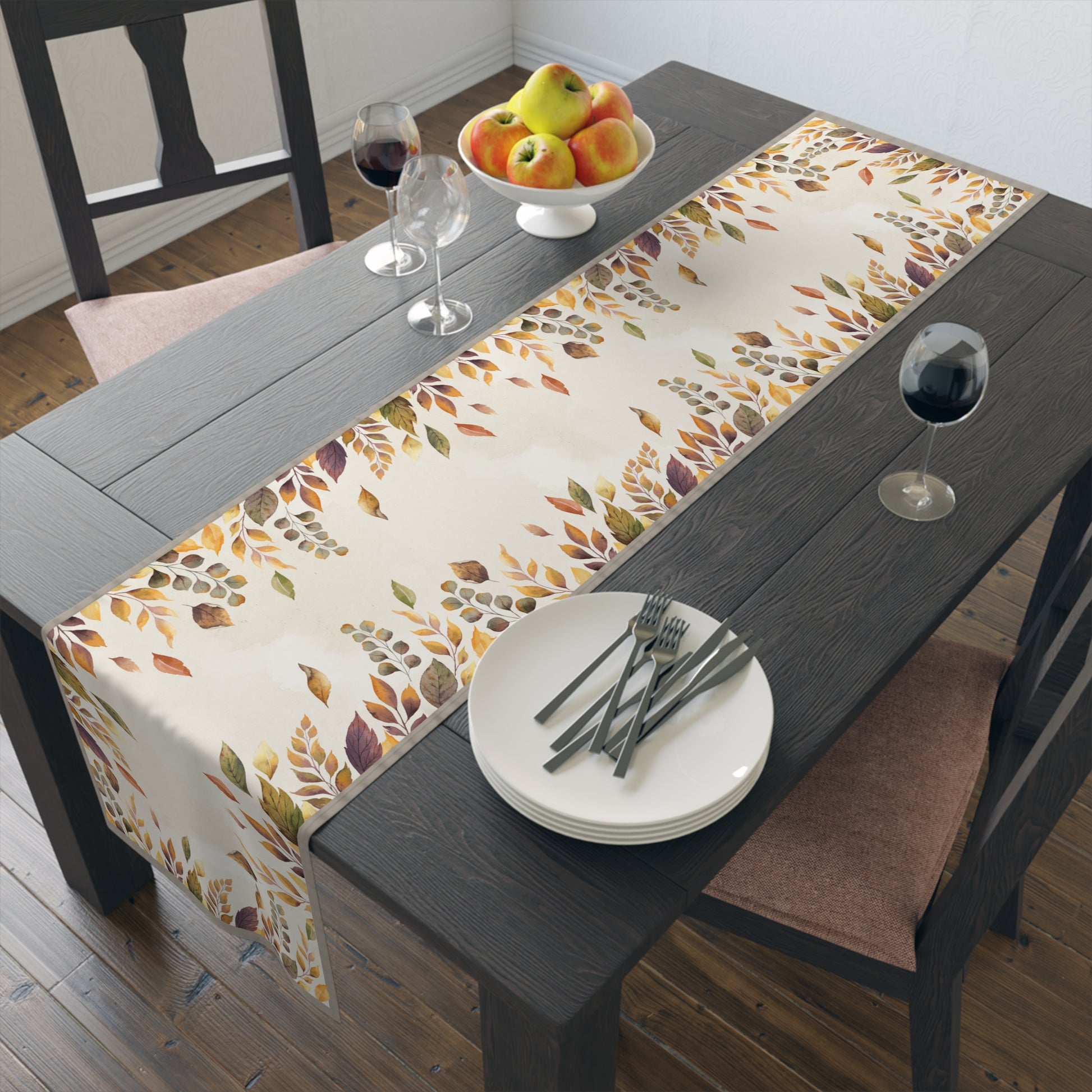 Dining table with a fall-themed table runner, plates, and glasses.