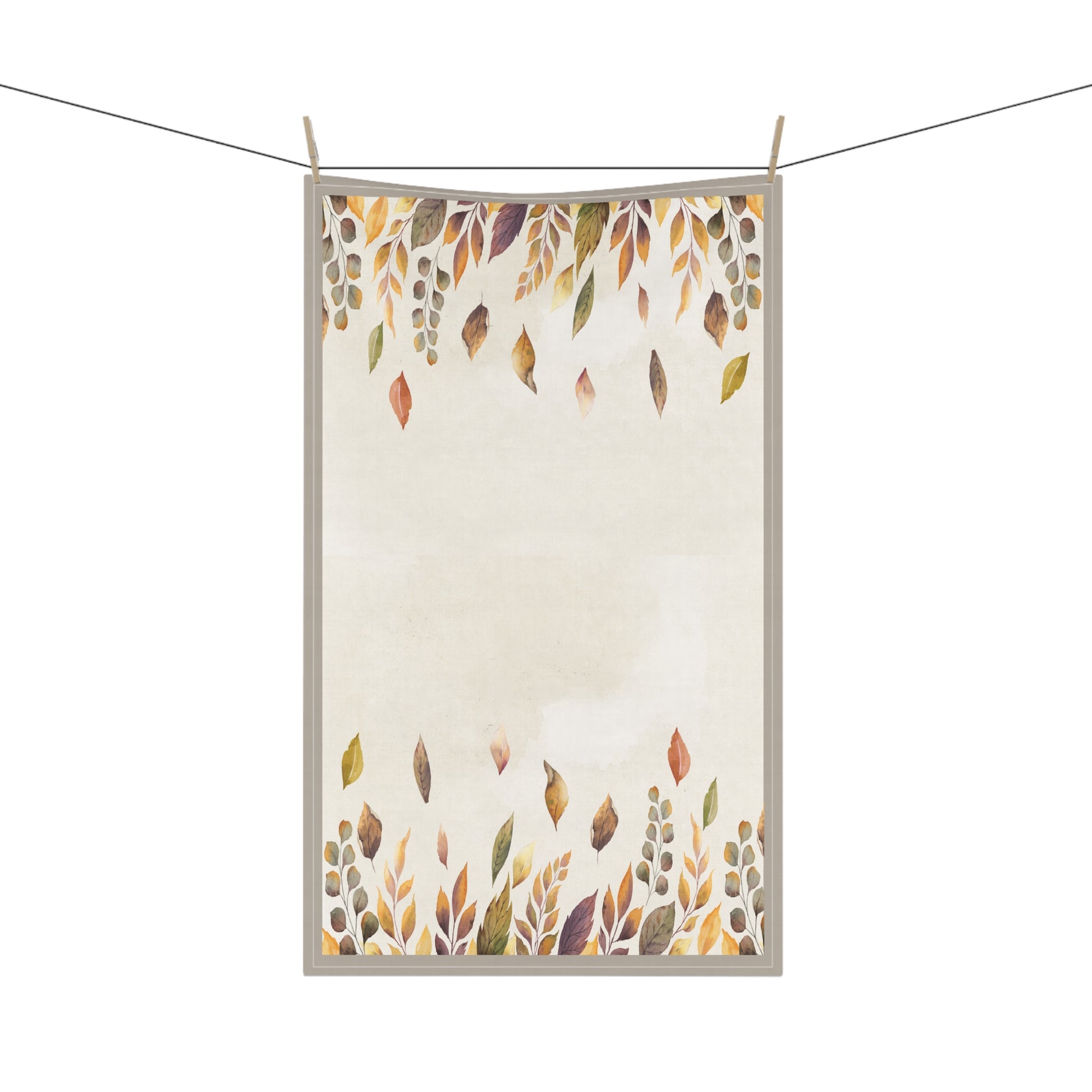Tea towel with autumn leaf pattern hanging on a line