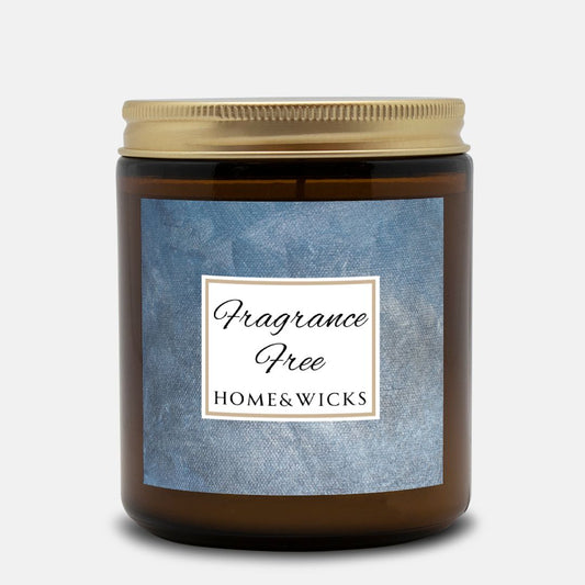 Unscented Candle in an amber jar with gold lid with 'Fragrance Free' label on a denim blue background