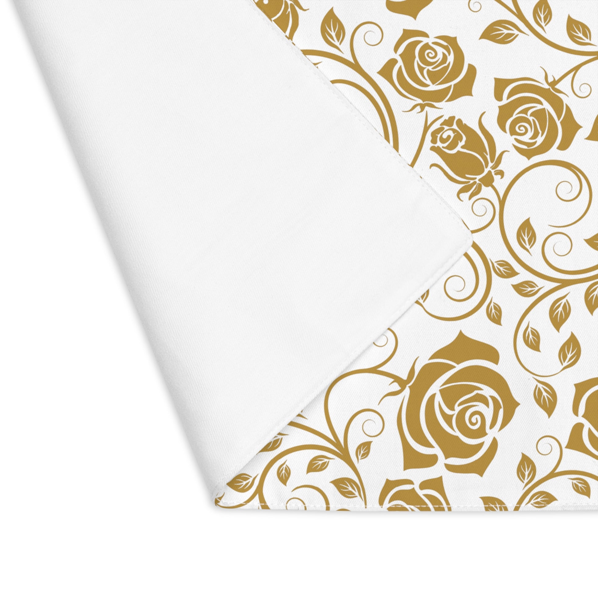 Gold floral pattern on placemat with one corner folded over to reveal white backside