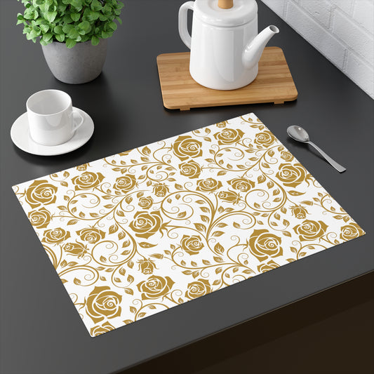 Placemat with gold rose pattern on a dark surface with tea set and plant.